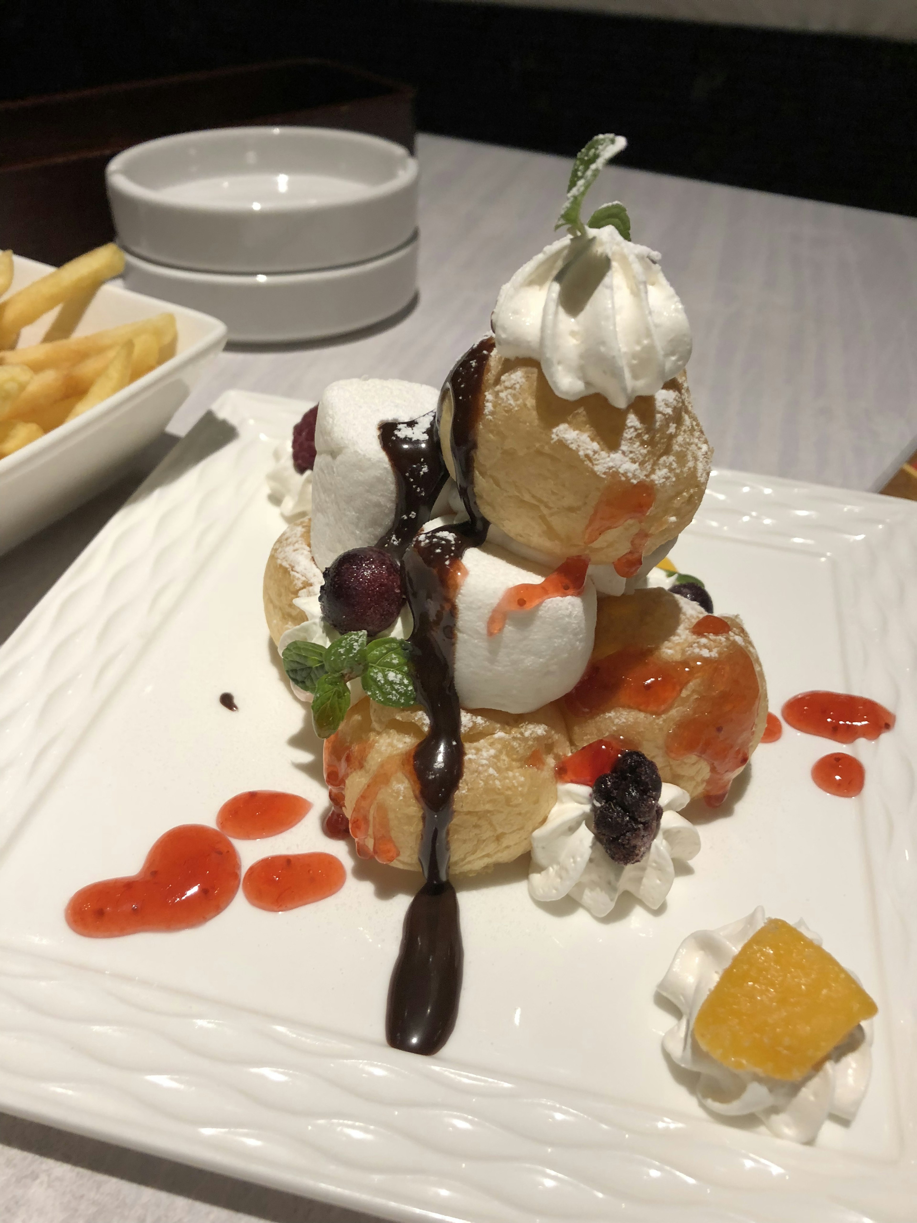 Dessert plate with ice cream topped with cream and fruit