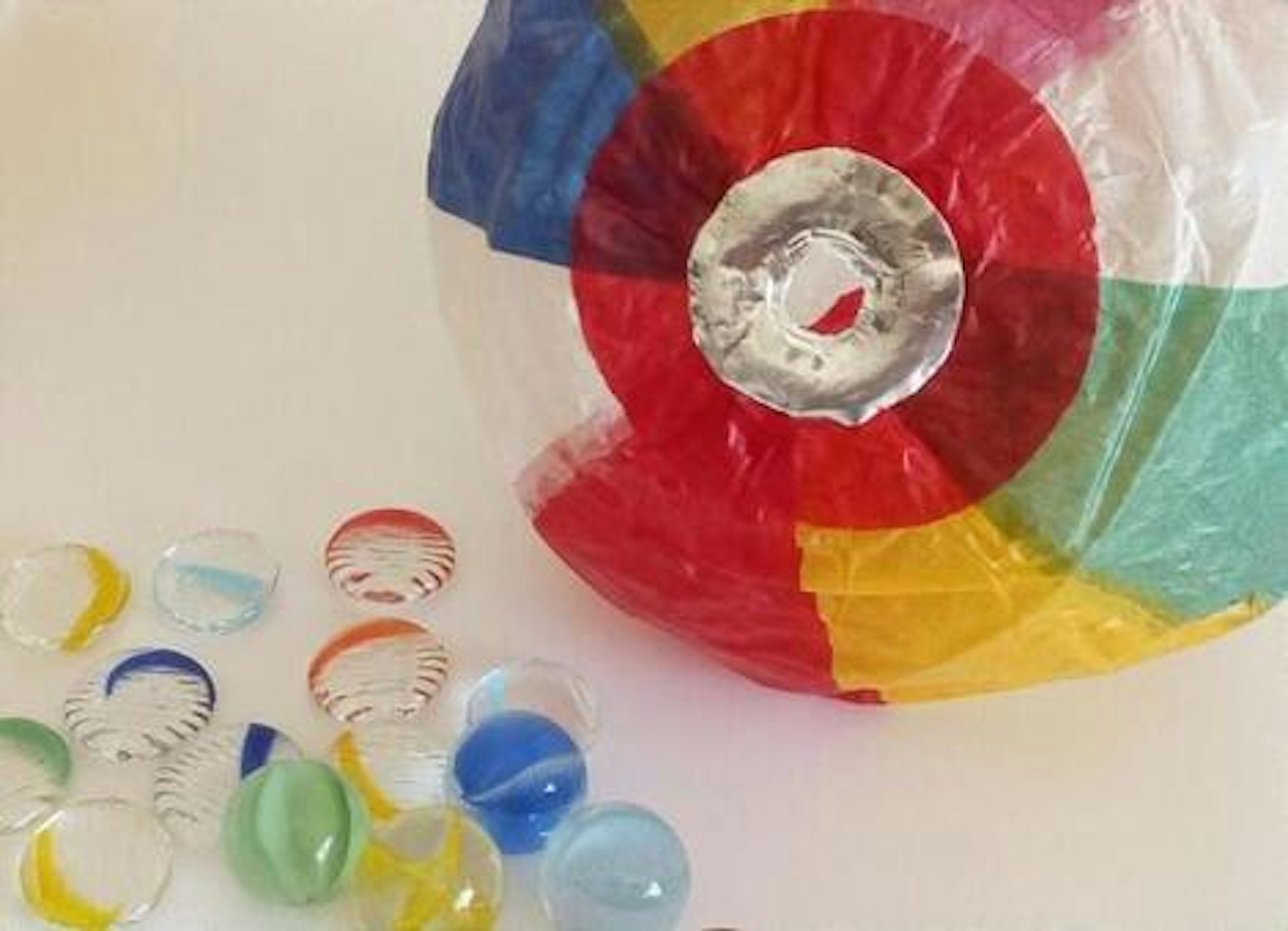 Colorful beach ball next to glass marbles