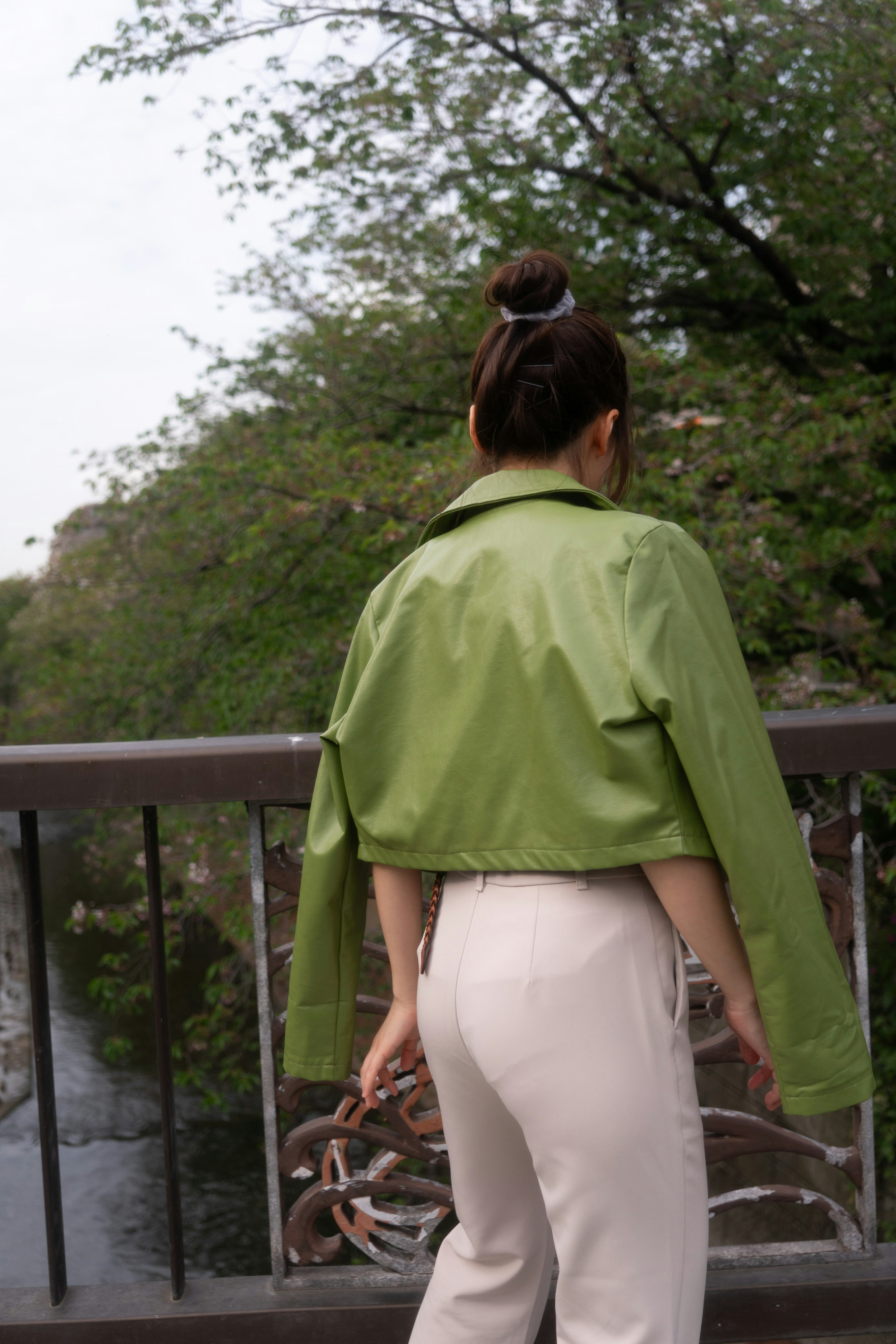 Femme portant une veste verte debout près d'une rivière