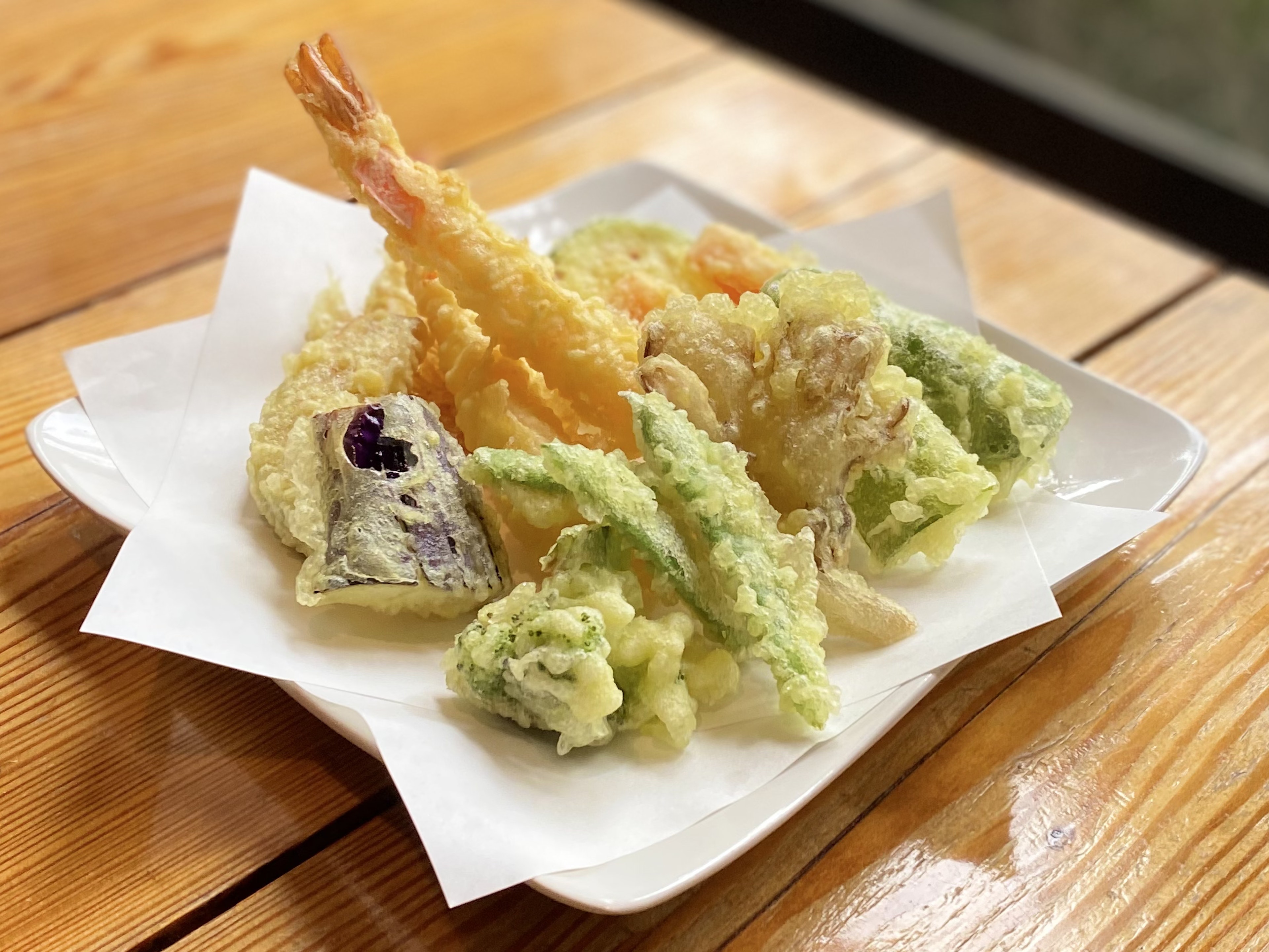 Une assiette de tempura avec des crevettes et divers légumes