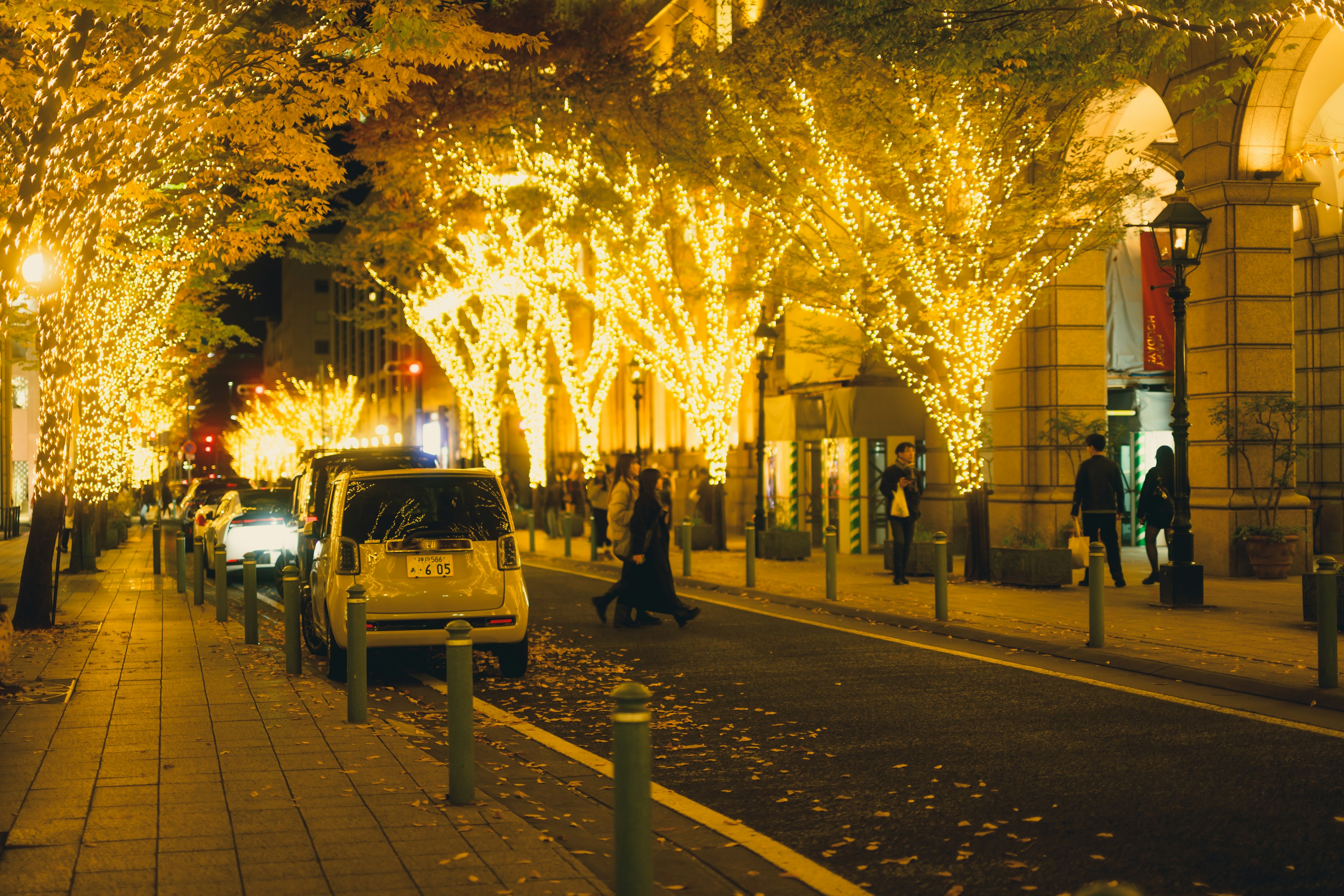 Strada illuminata con luci scintillanti e pedoni di notte