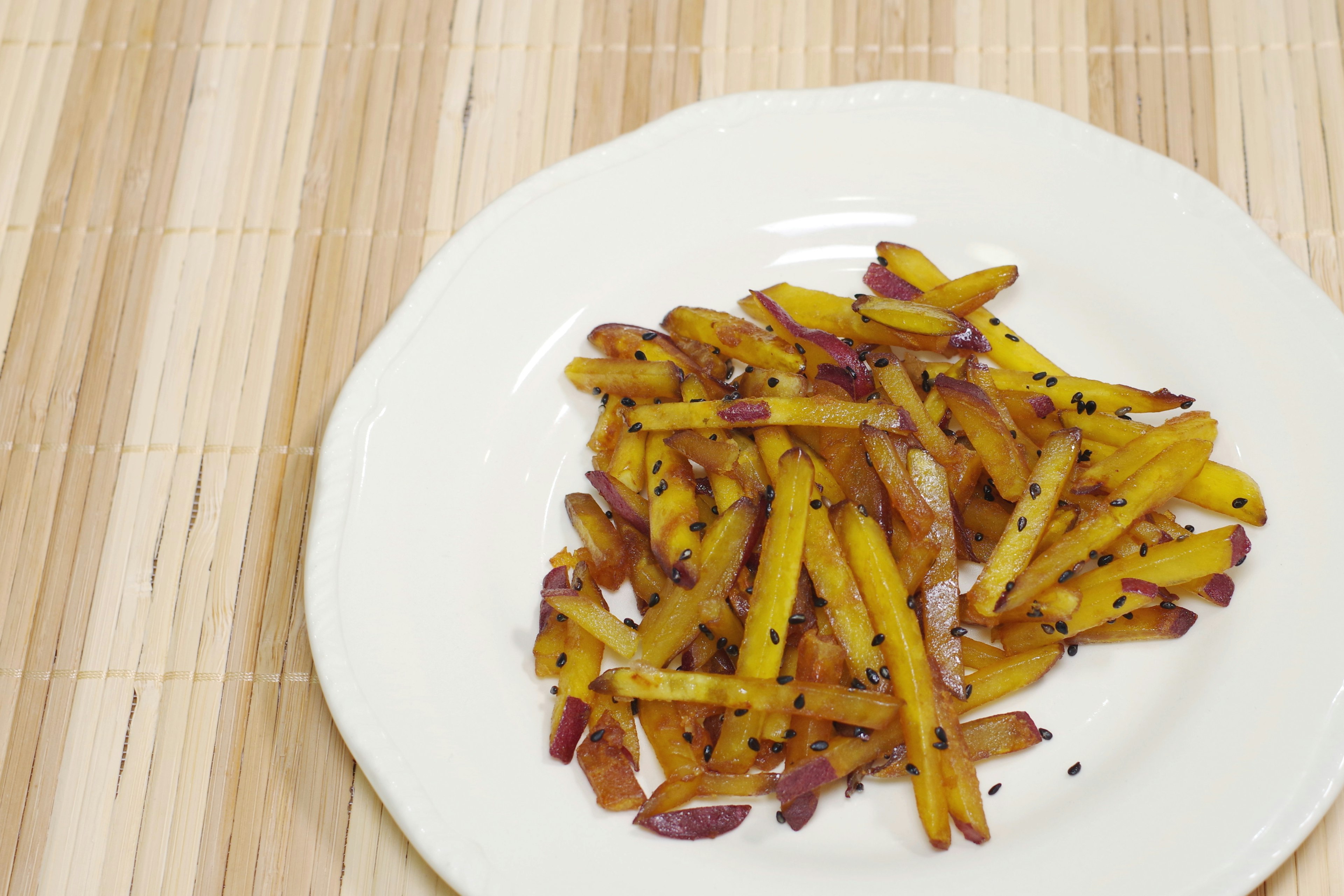 Strisce di patate fritte gialle e rosse su un piatto bianco