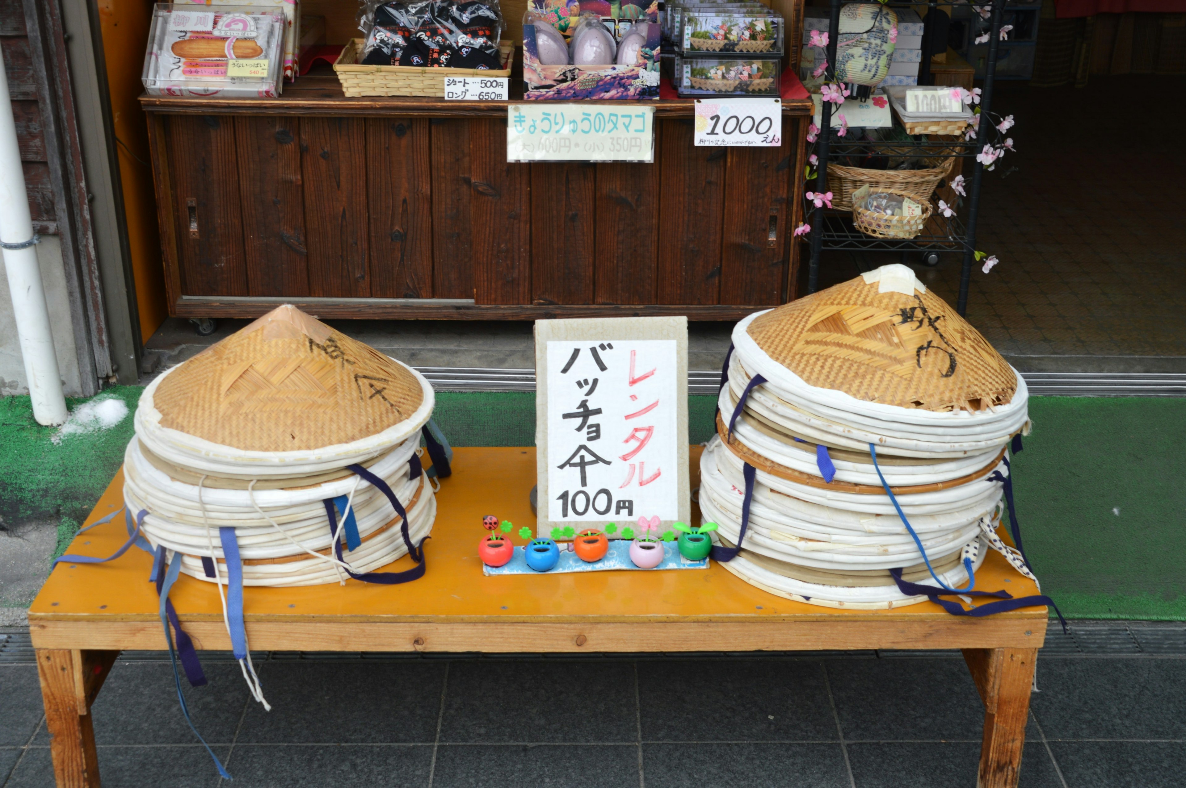 Grands conteneurs de sable exposés devant un magasin avec un panneau de prix