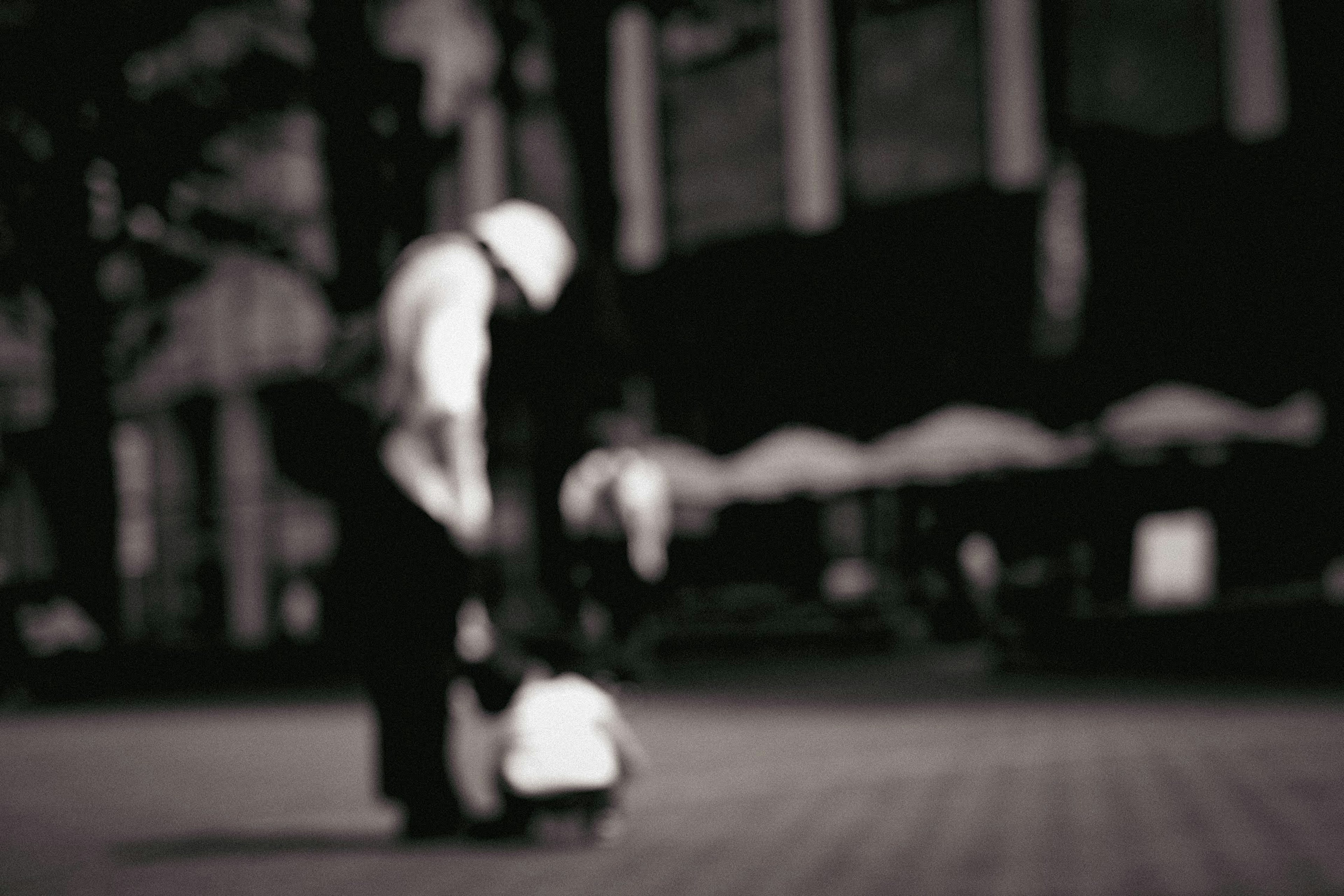 A blurred background featuring a man in a hat with a small child