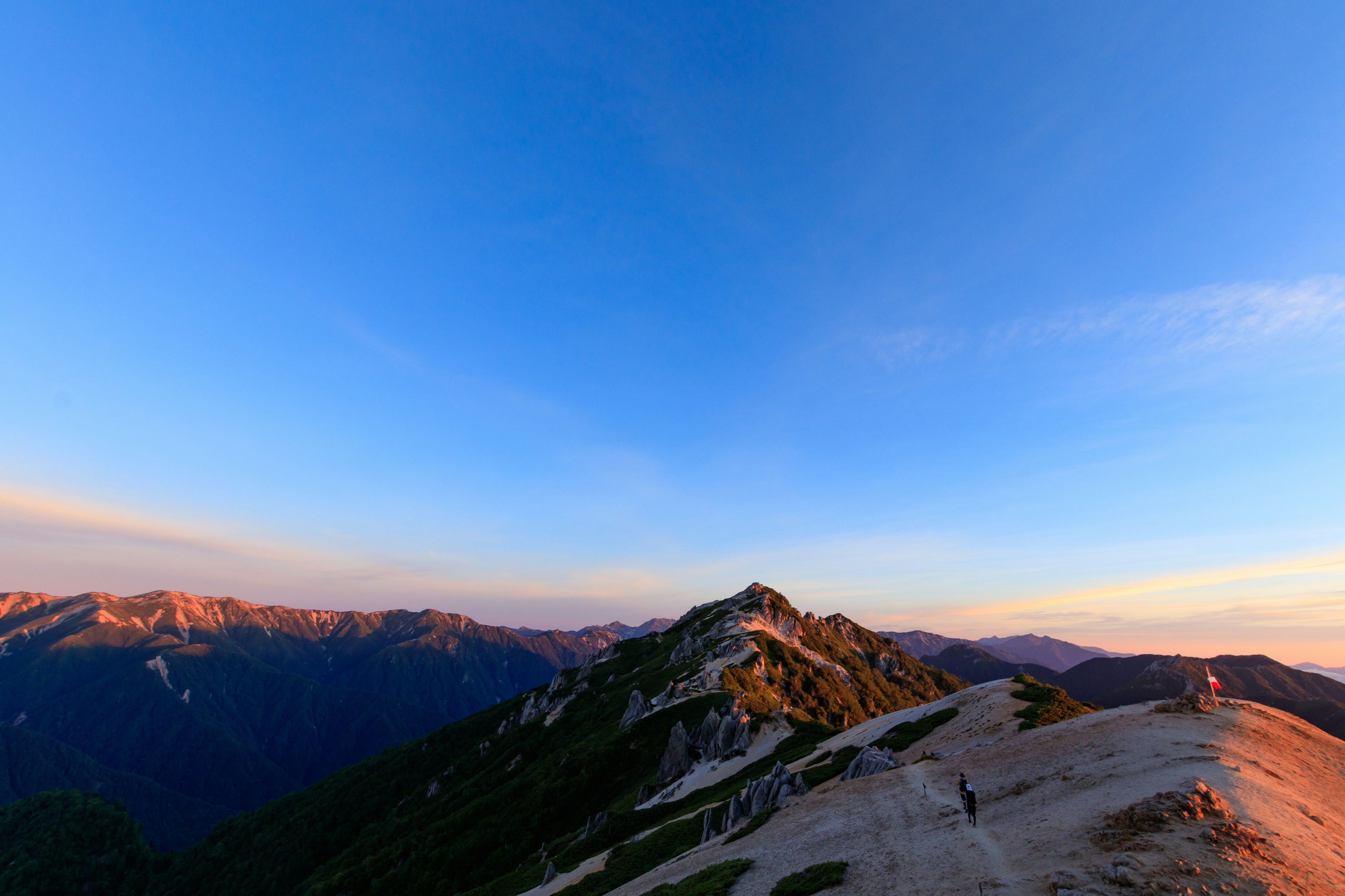 Vista panorámica de montañas bajo un cielo azul durante el atardecer