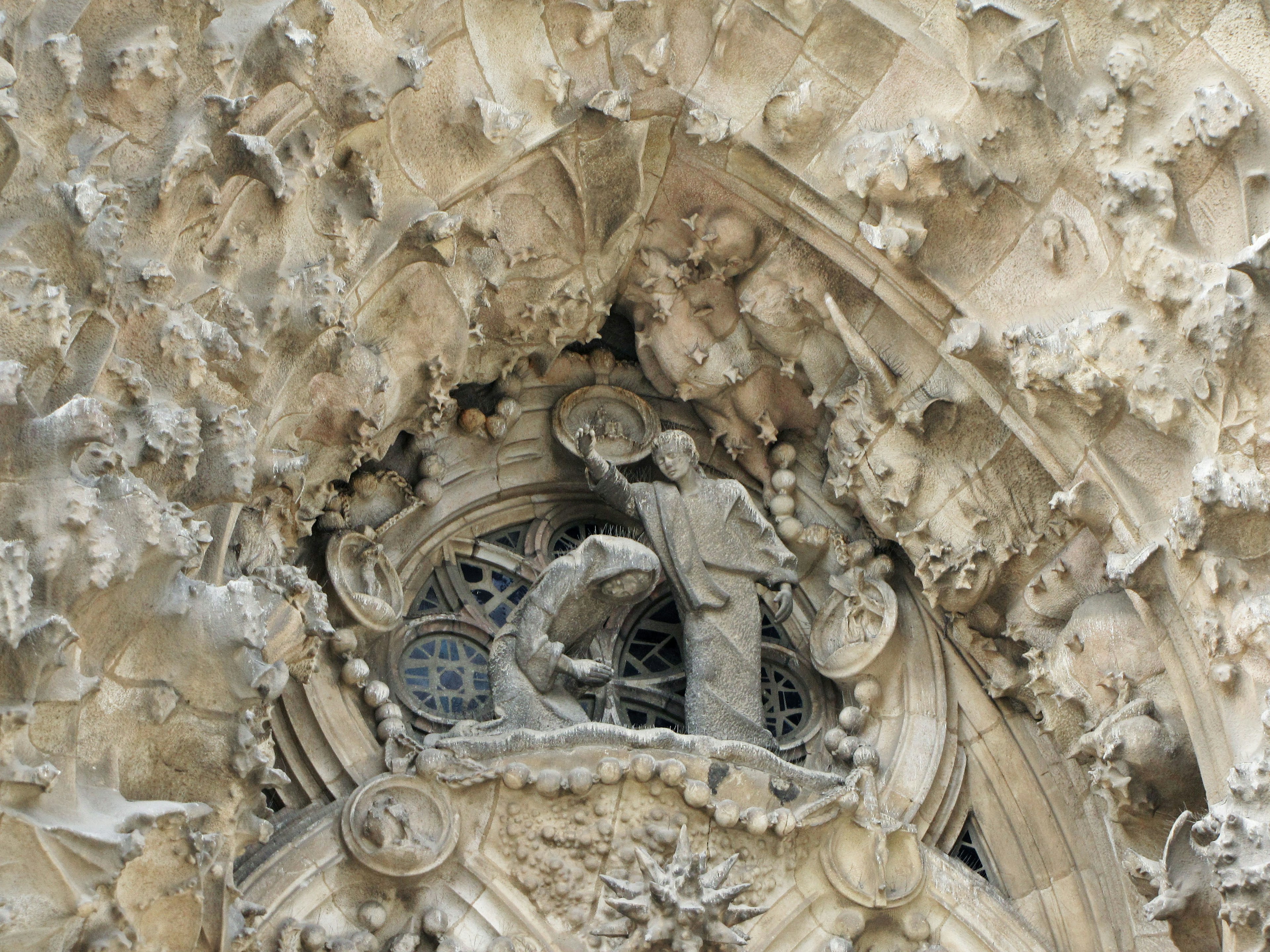 A detailed sculpture of a figure and an animal at the top of a church entrance