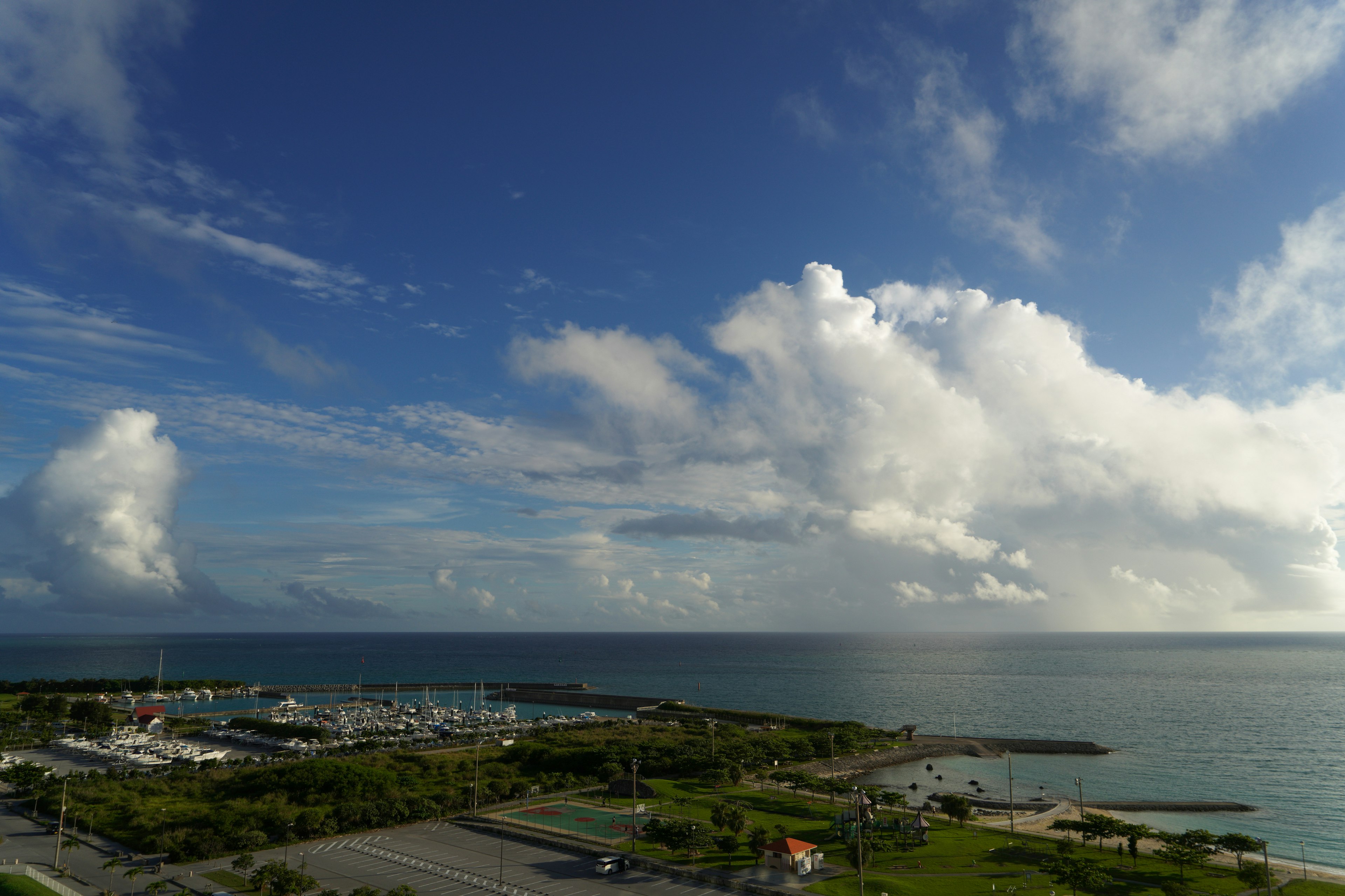 Vue pittoresque de l'océan et du ciel avec un port de plaisance et un parc verdoyant