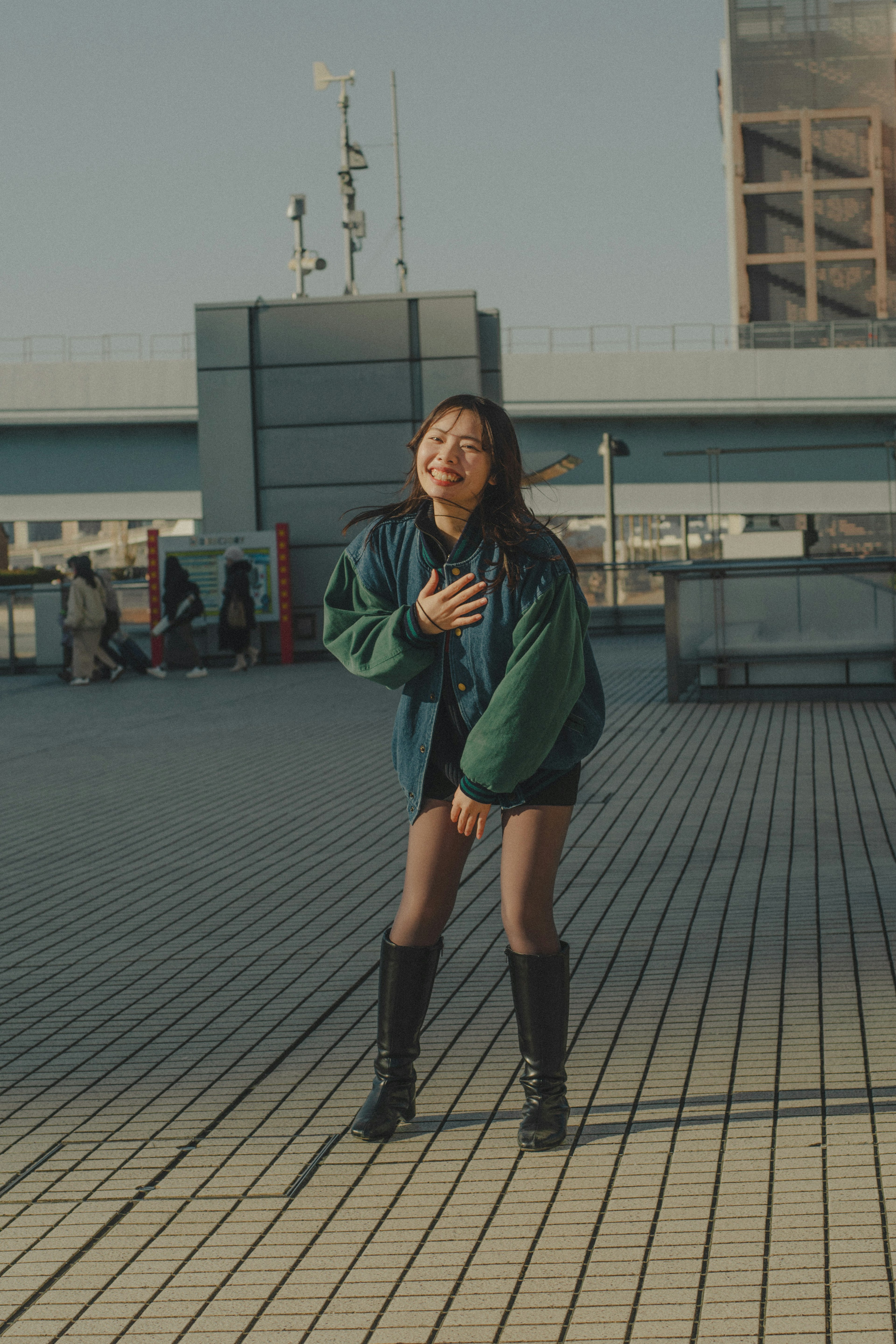 A woman in a green jacket striking a pose in an urban setting