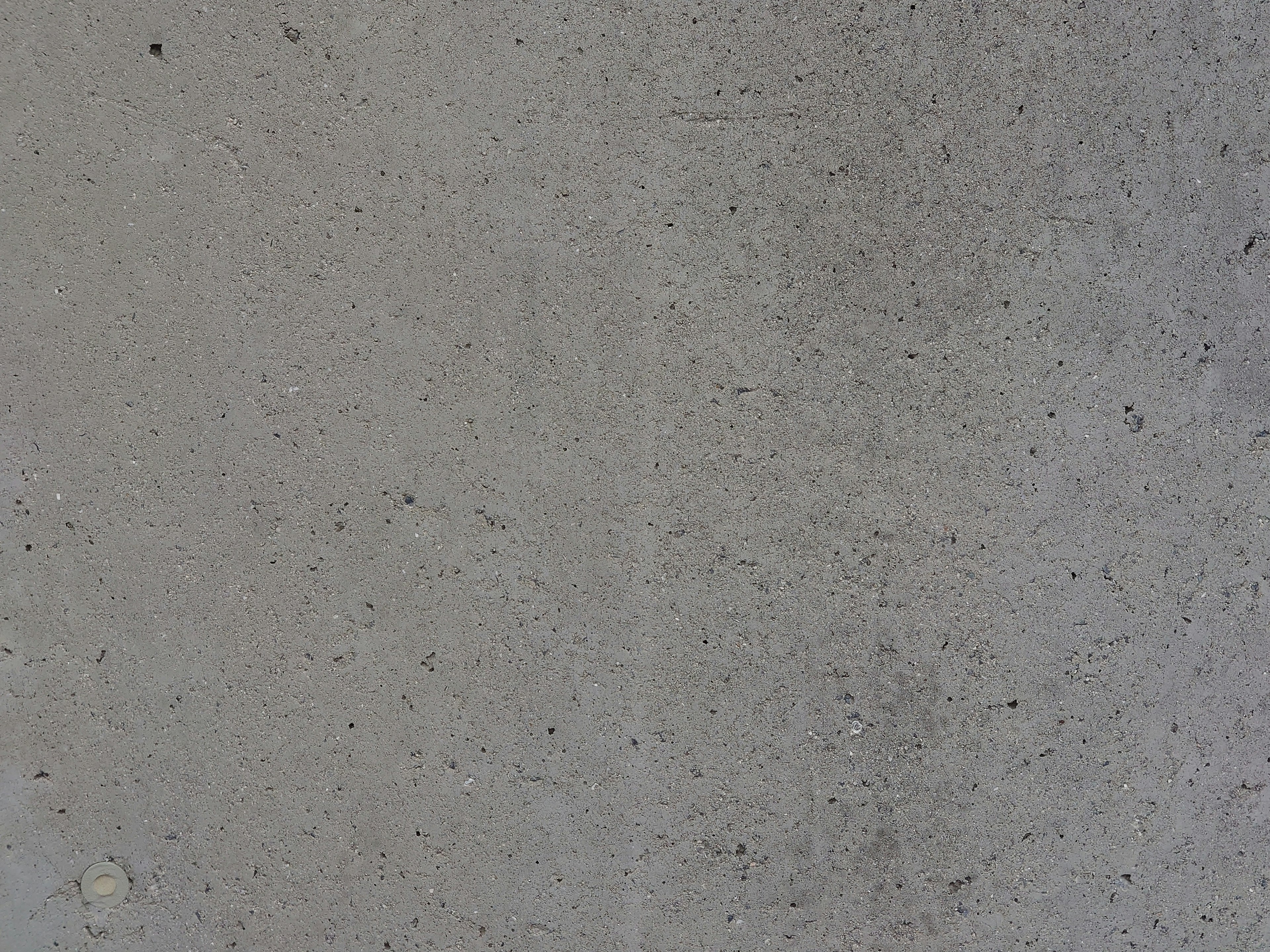 Close-up of concrete texture showing a light gray surface with fine particles