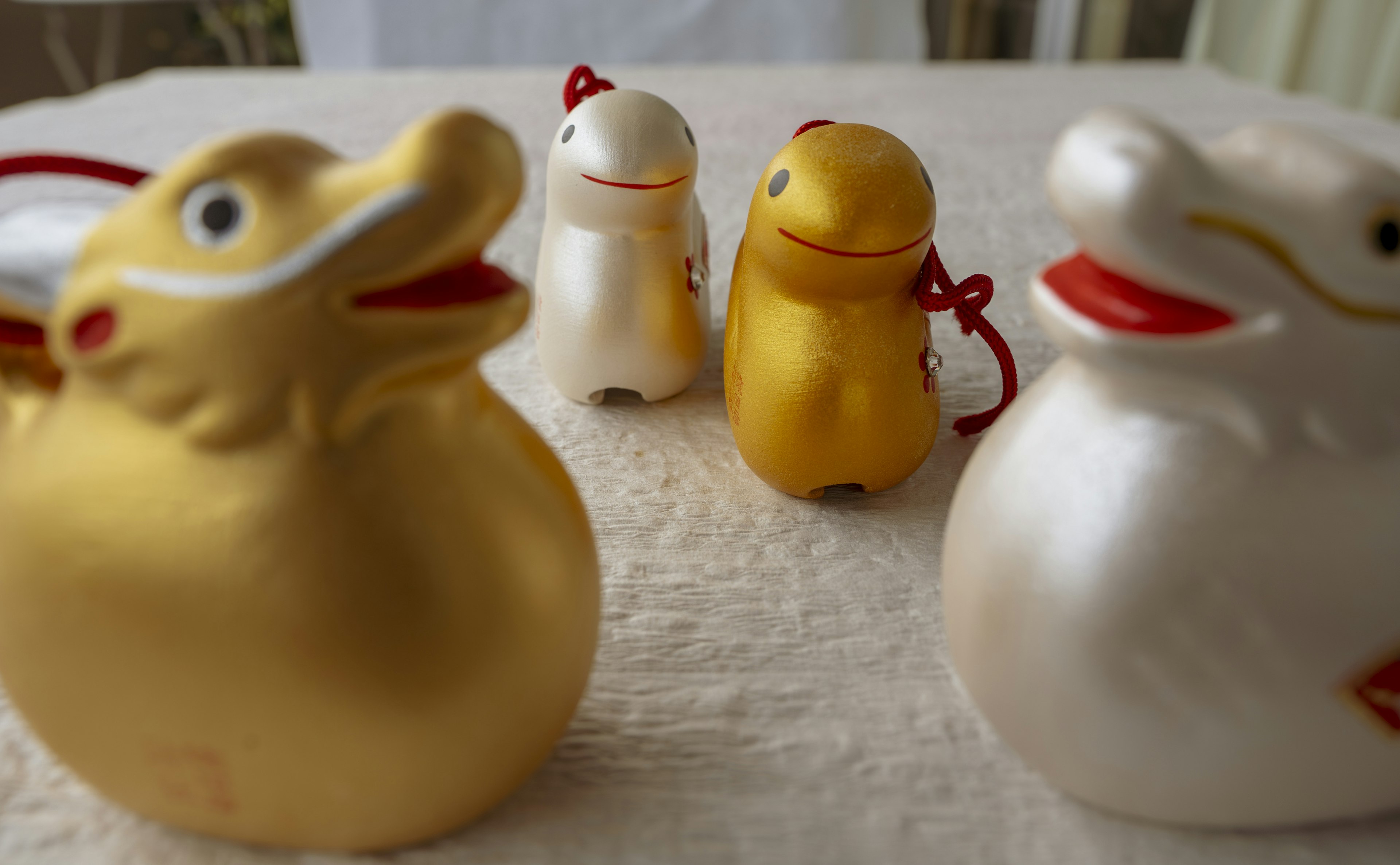 Photo de figurines en forme de canard dorées et blanches disposées sur une table