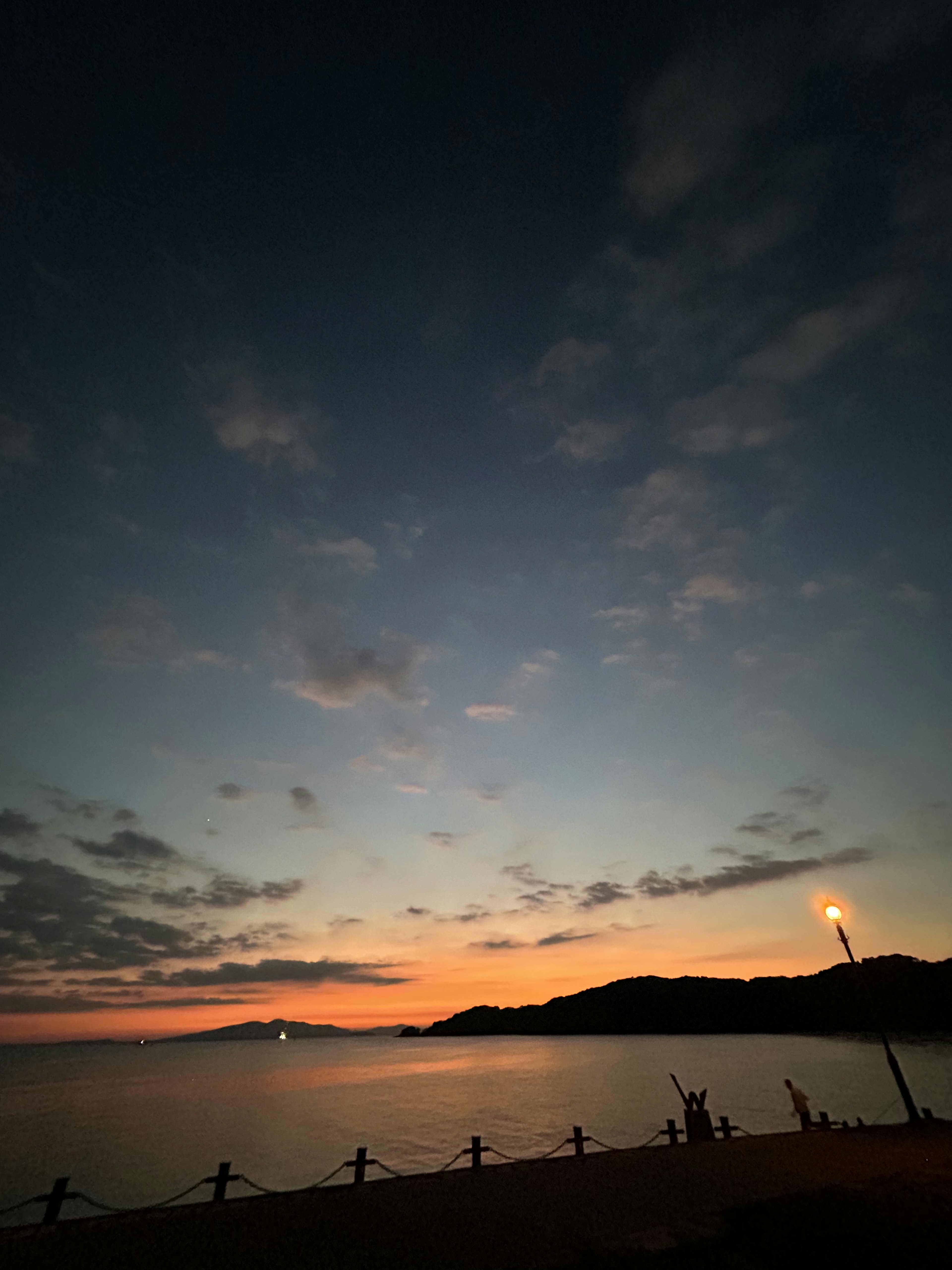 夕焼けの海岸線と静かな水面の景色