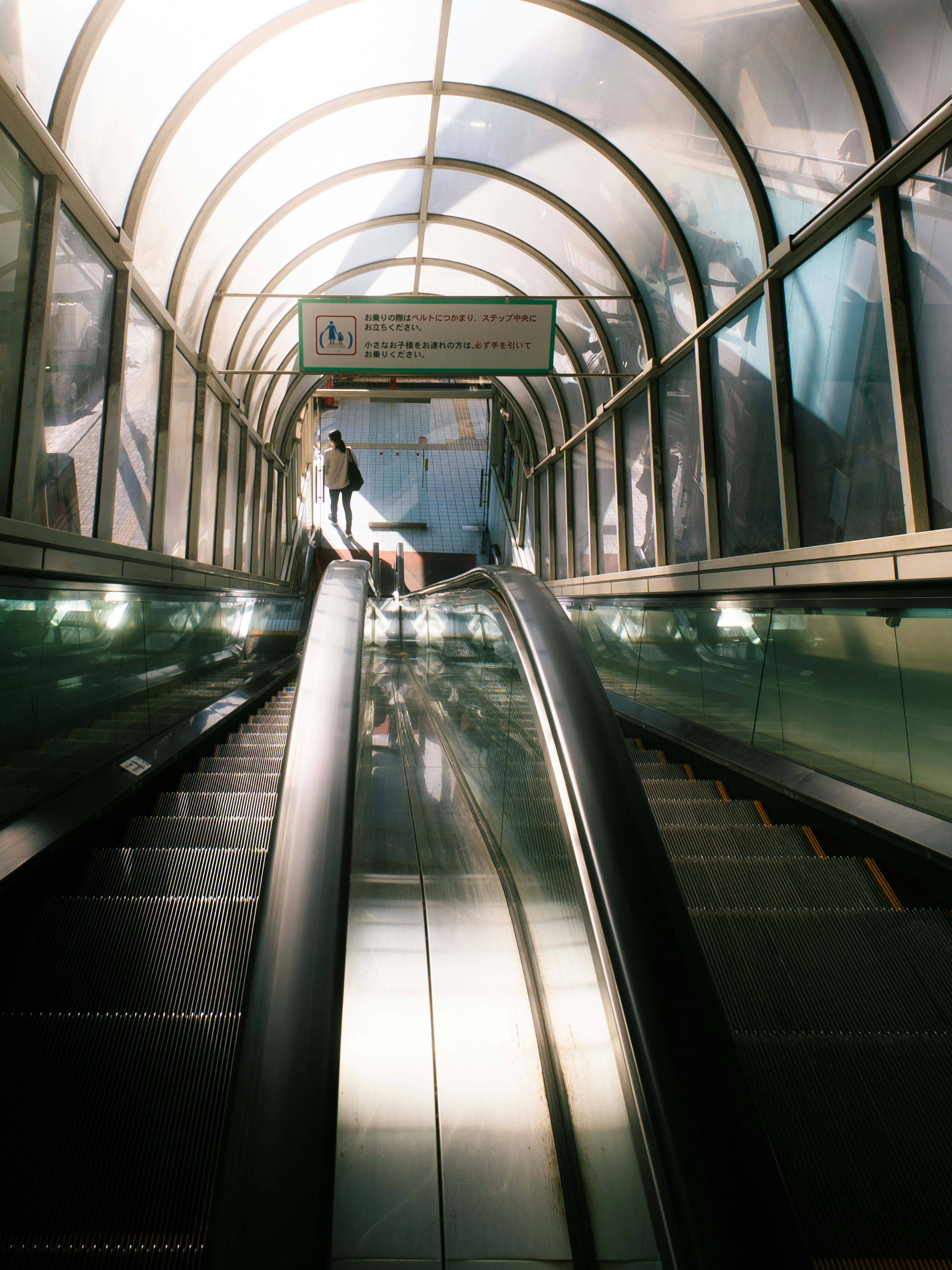 Escalator tunnel with transparent roof Light streaming through from inside