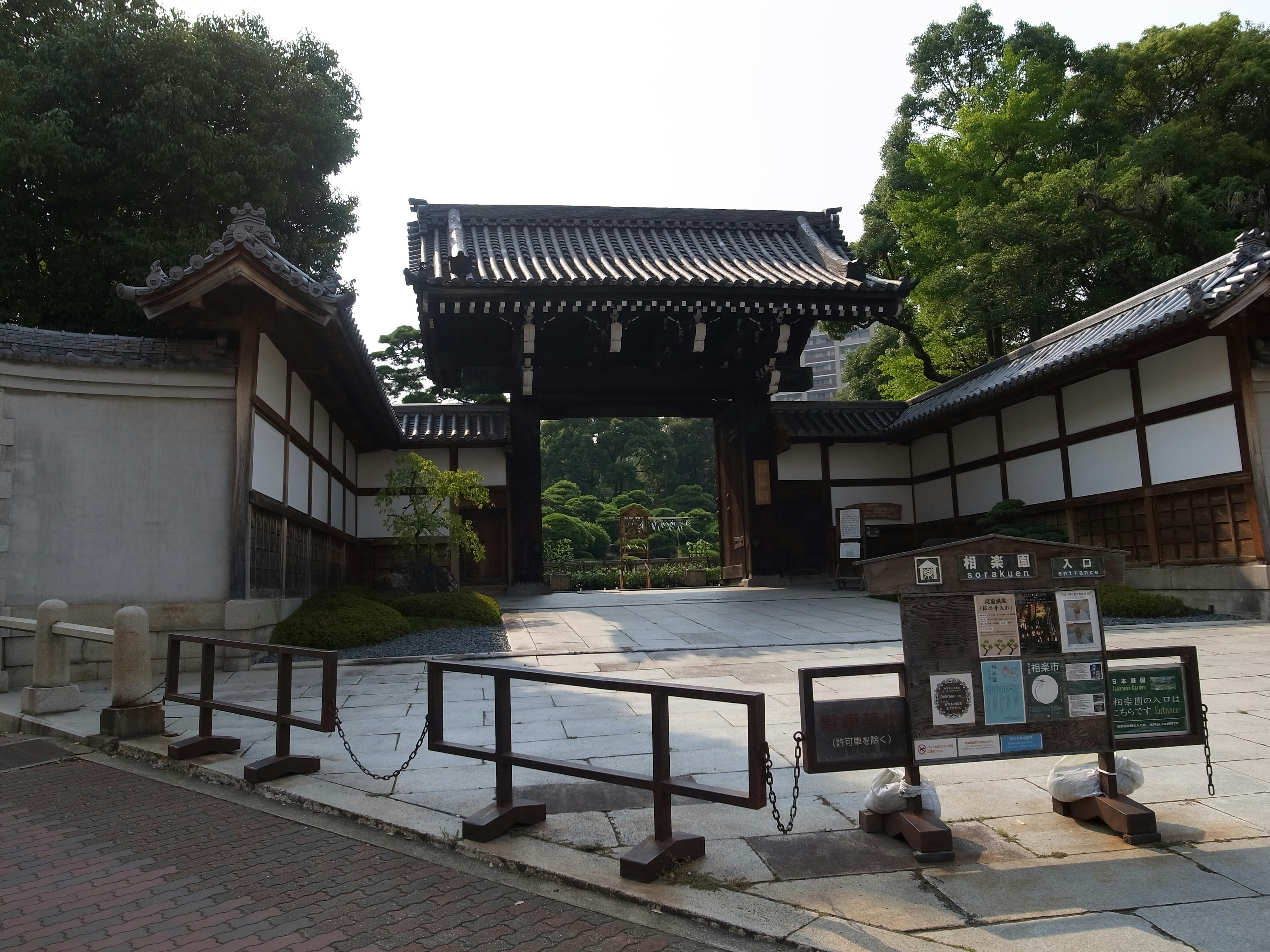 Traditional Japanese temple gate with surrounding garden