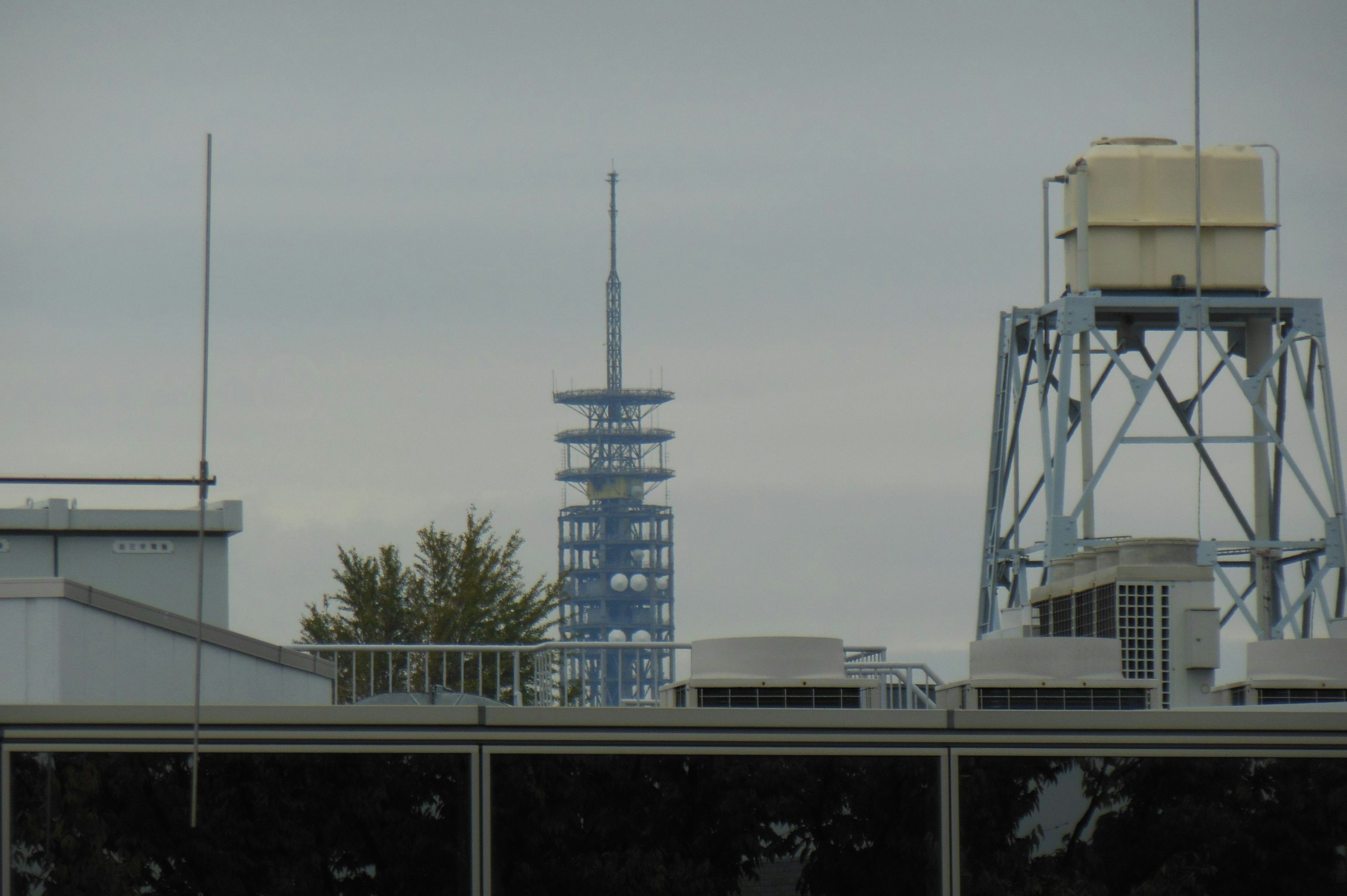 Blick auf einen blauen Turm mit Dächern und Wassertank