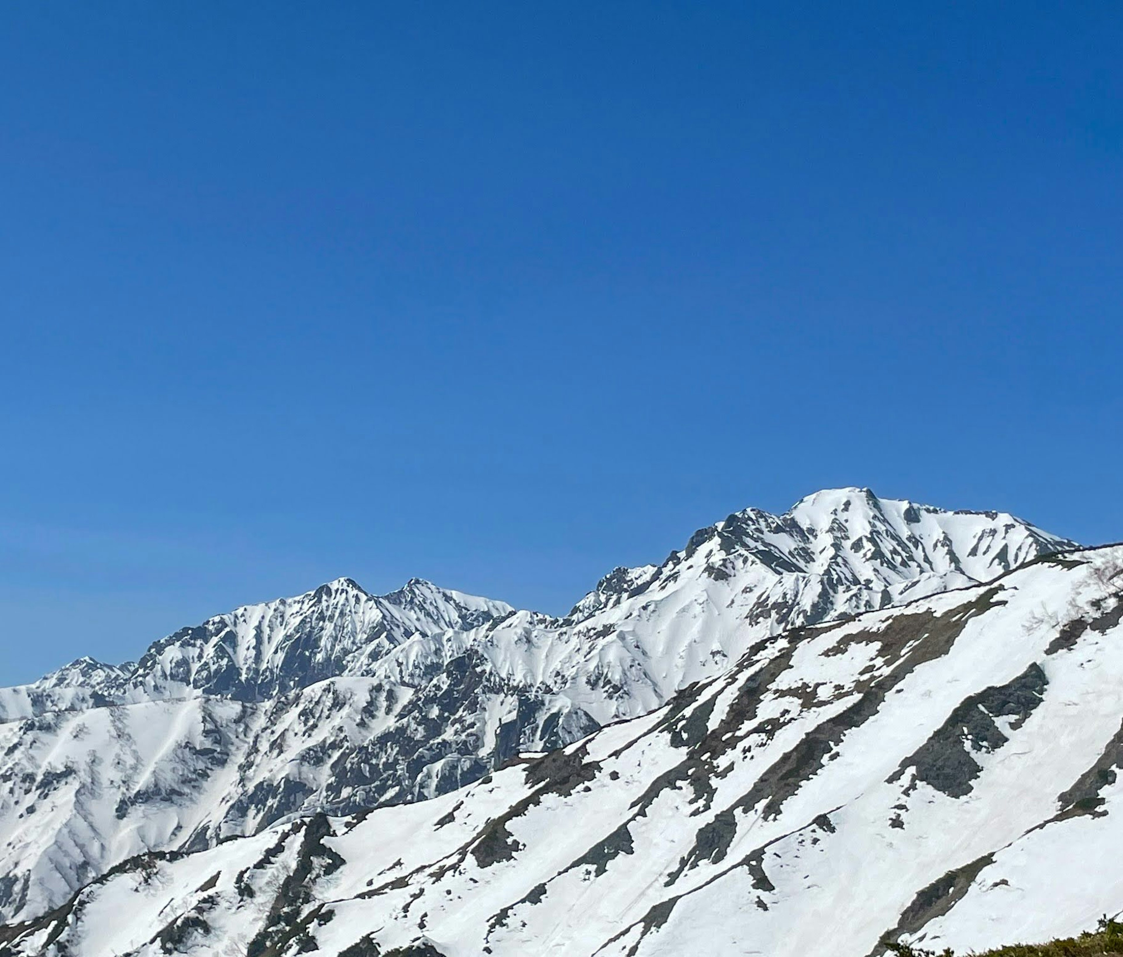 Snow-covered mountains under a clear blue sky