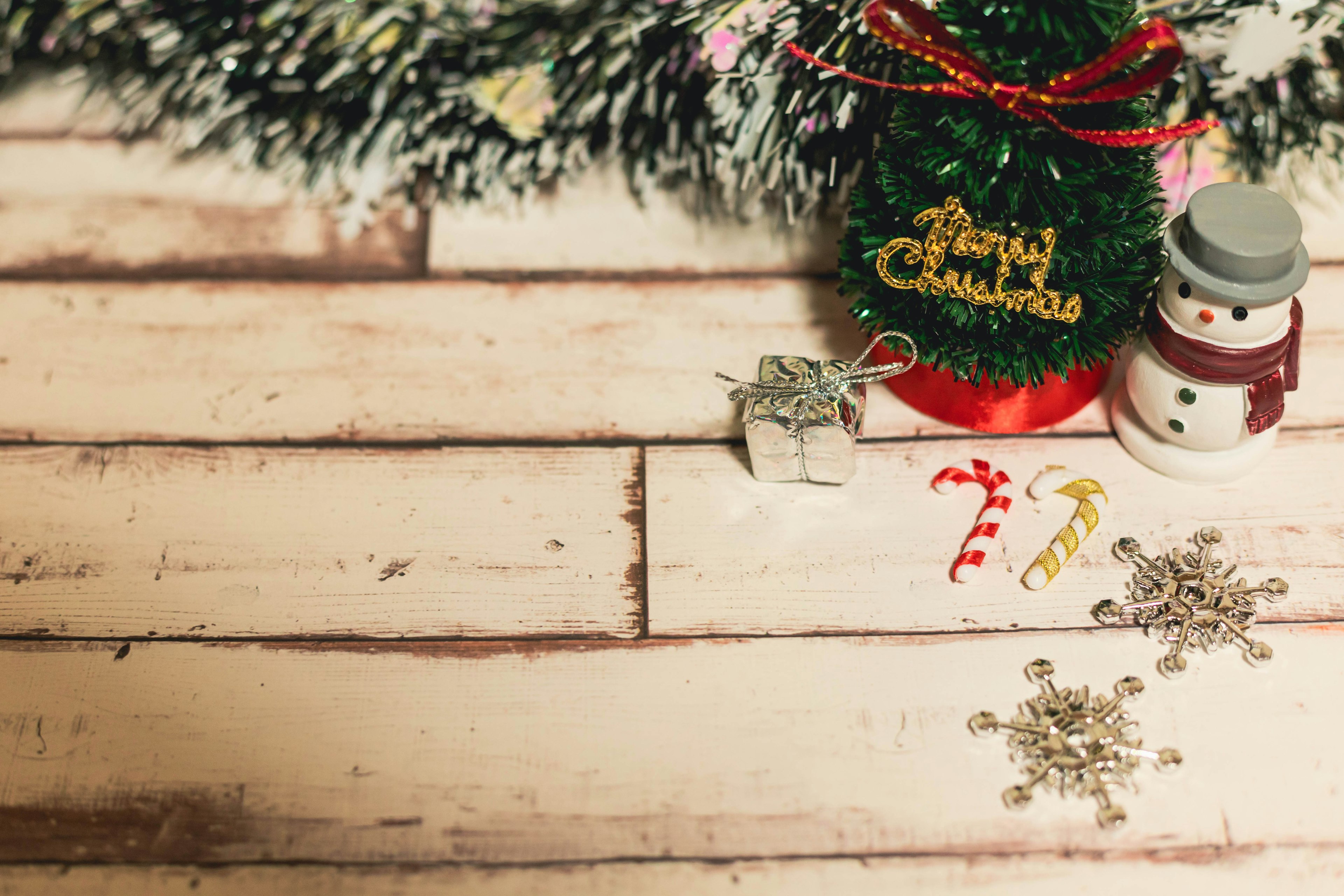 Christmas decorations including a snowman and a Christmas tree on a wooden table