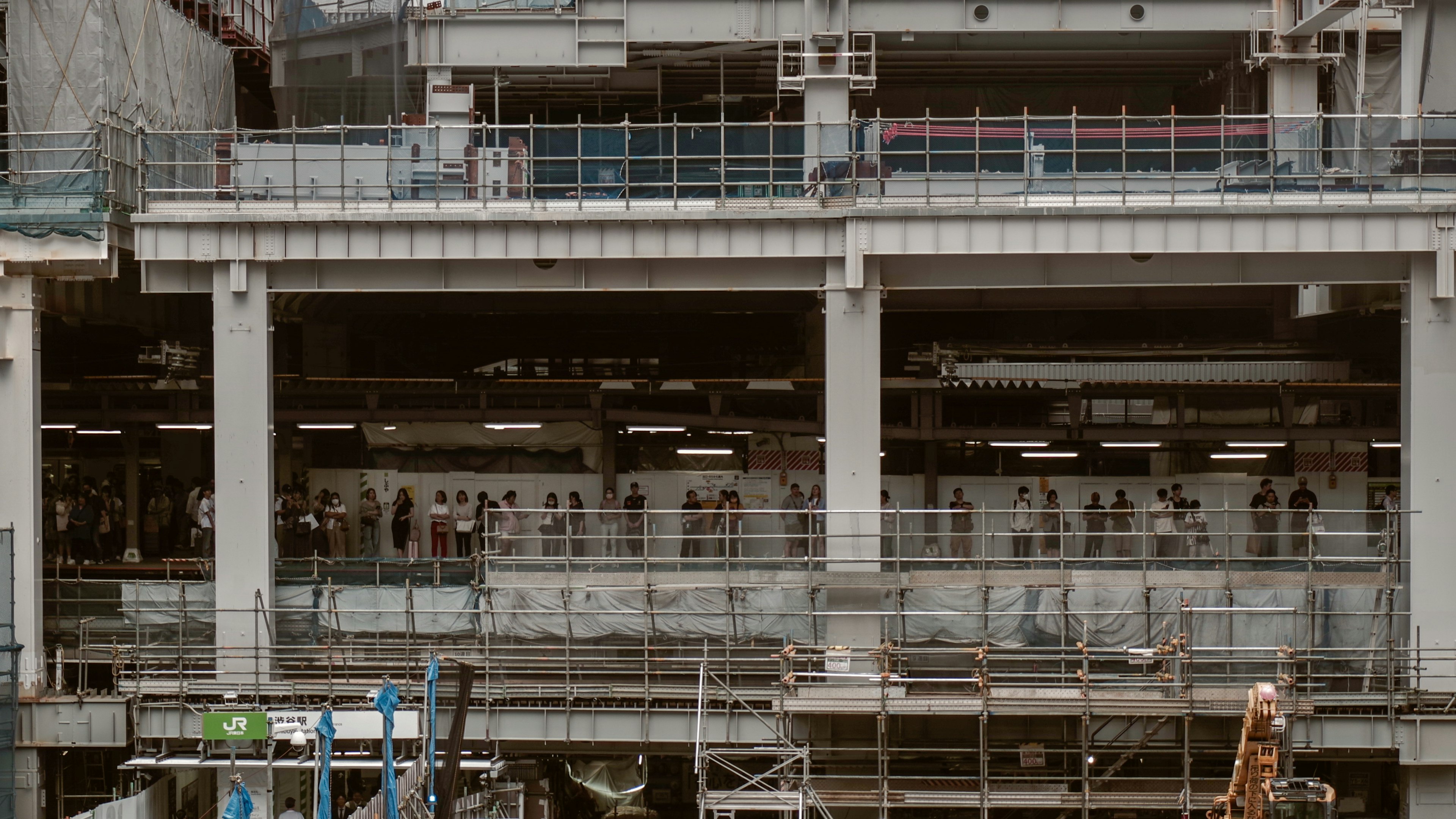 ภาพของอาคารที่กำลังสร้างพร้อมคนงานหลายคนที่มองเห็นได้