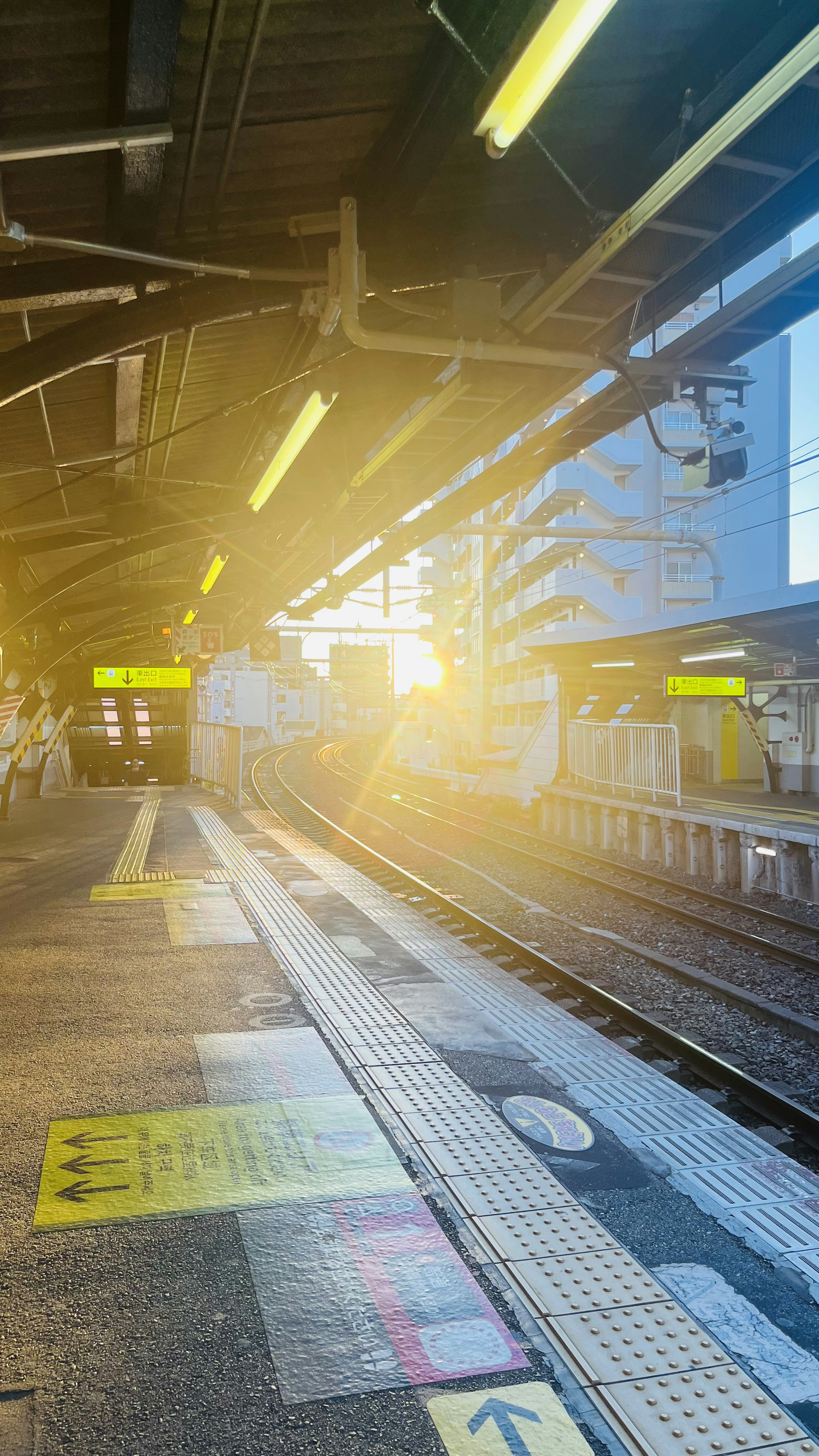 駅のプラットフォームでの朝日が差し込む風景