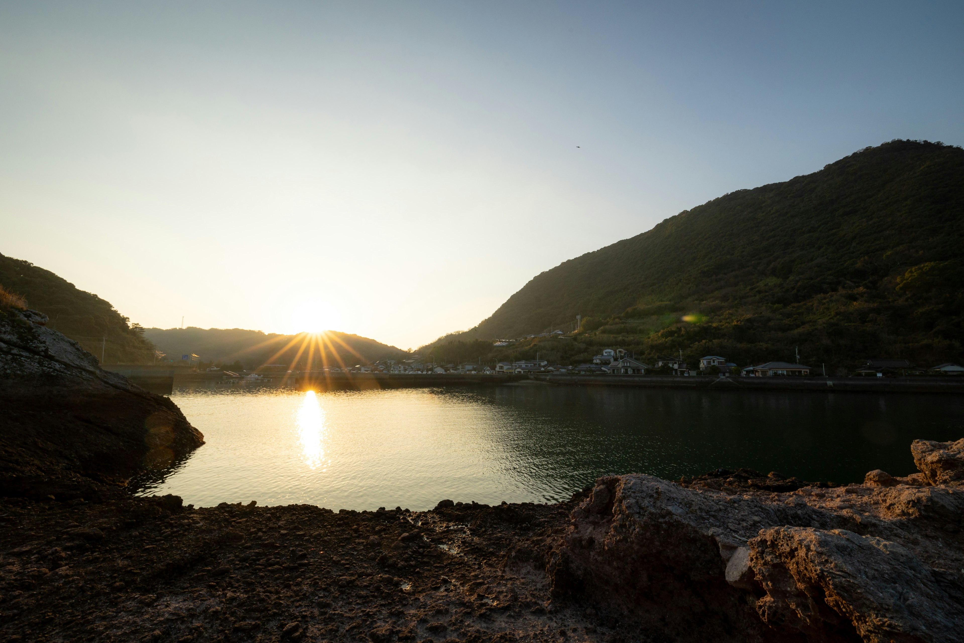 Coucher de soleil sur un lac tranquille avec des montagnes en arrière-plan