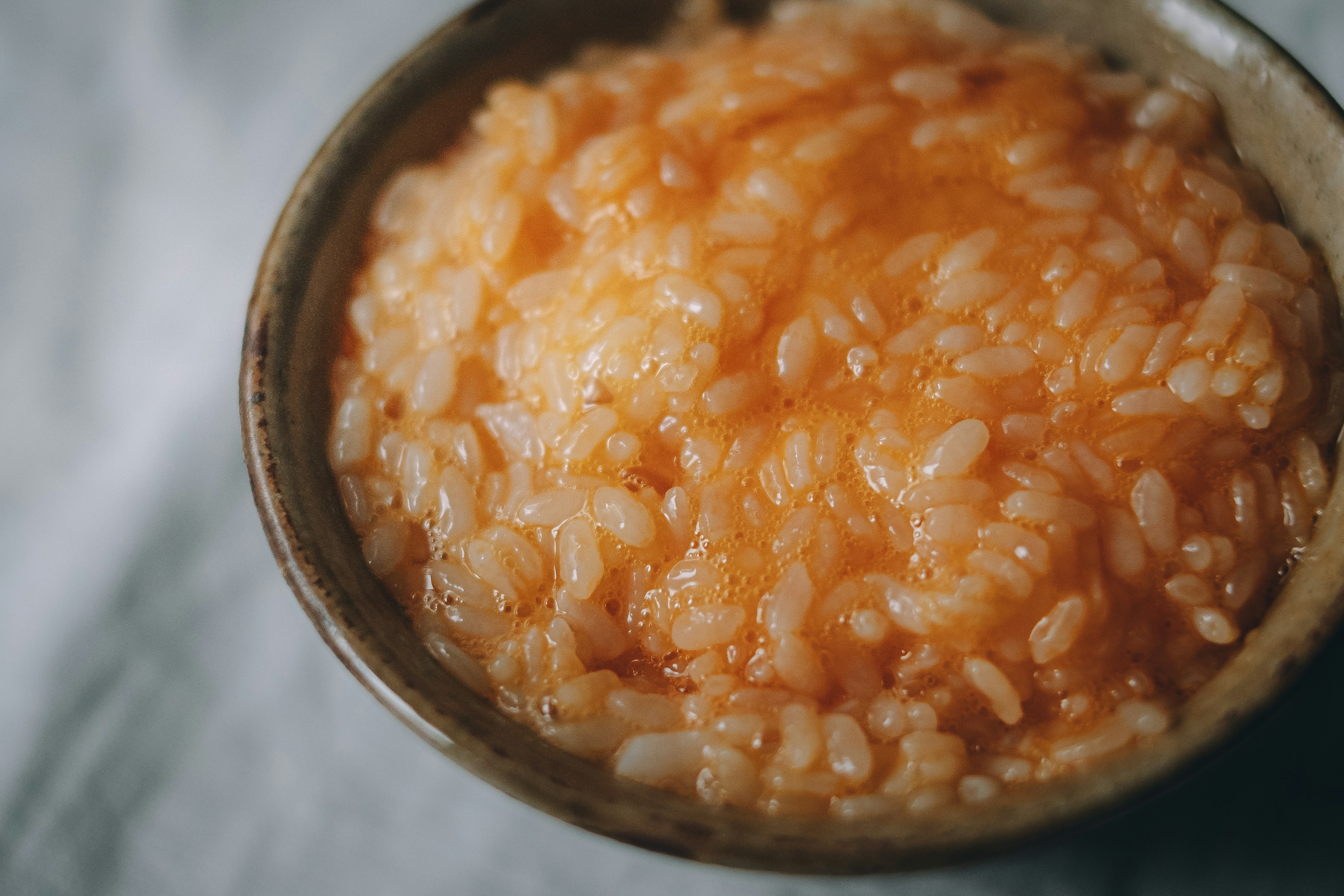 Un tazón de risotto naranja servido en un plato de cerámica