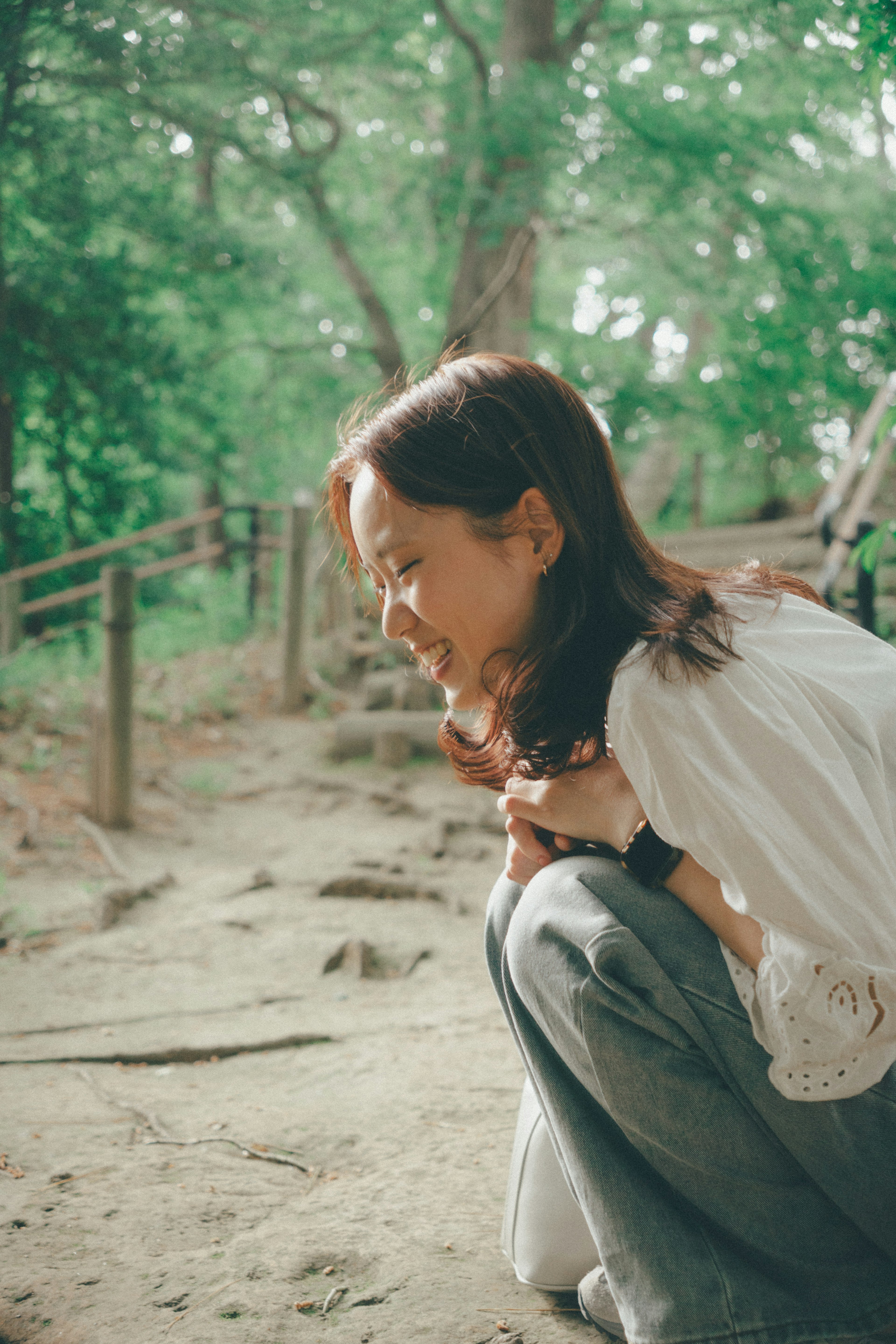 在绿色自然环境中蹲着的女性侧面