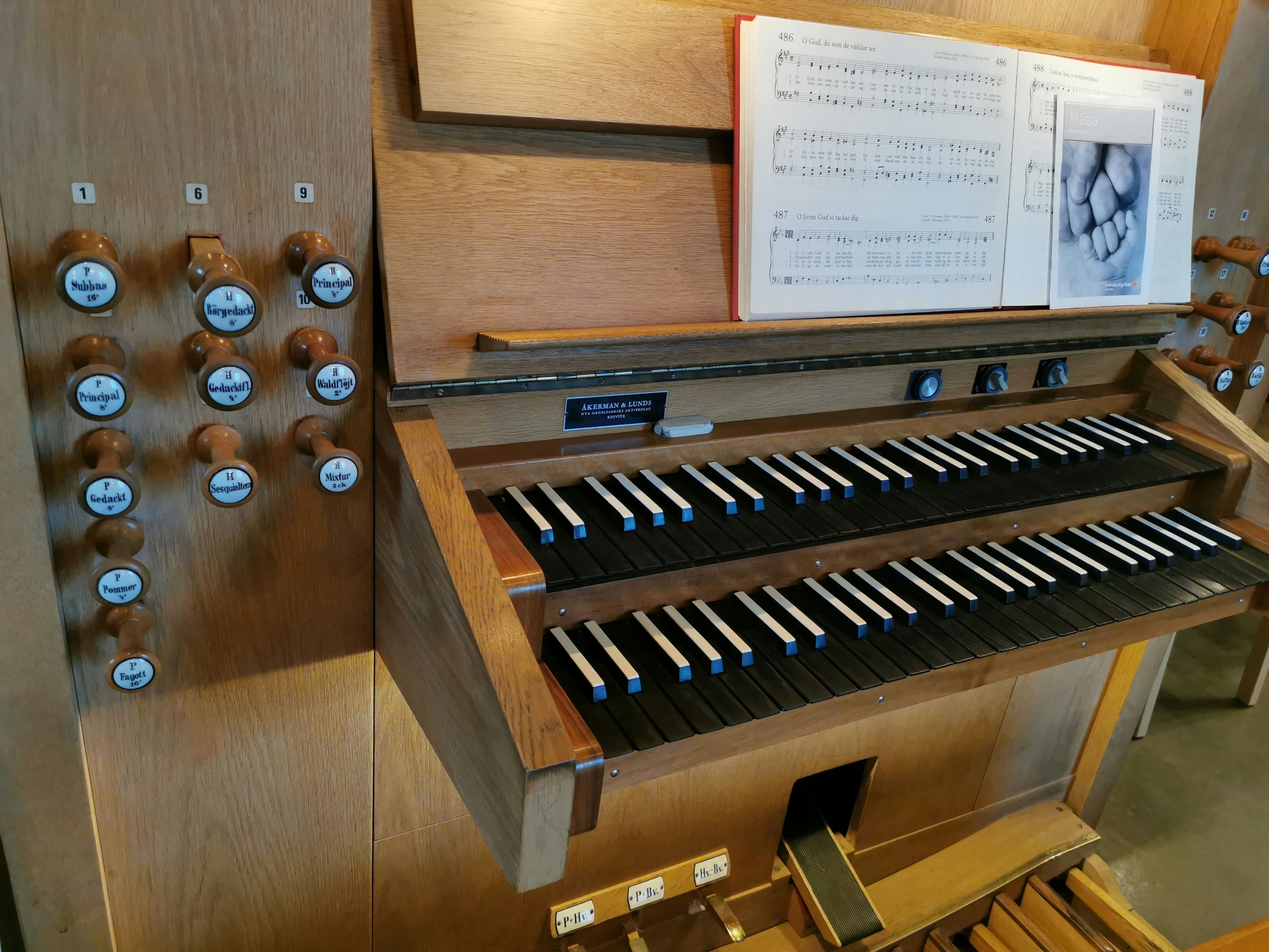 Organ kayu dengan kunci dan kontrol lembar musik terbuka di stand