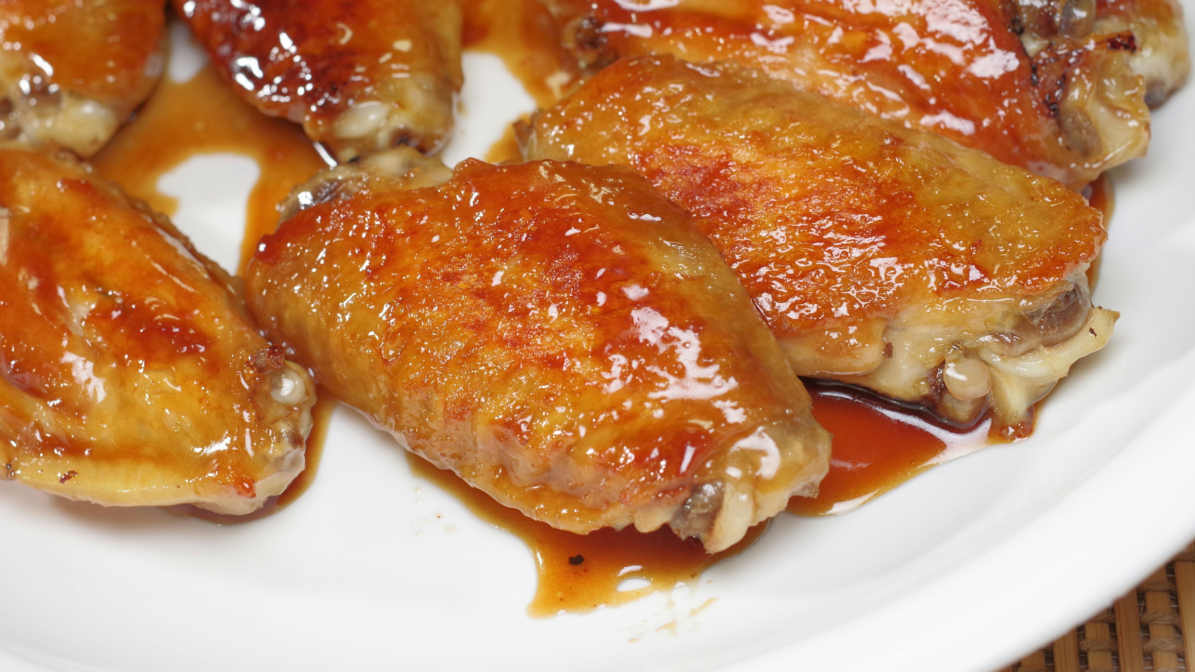 Plate of chicken wings coated in sweet and spicy sauce