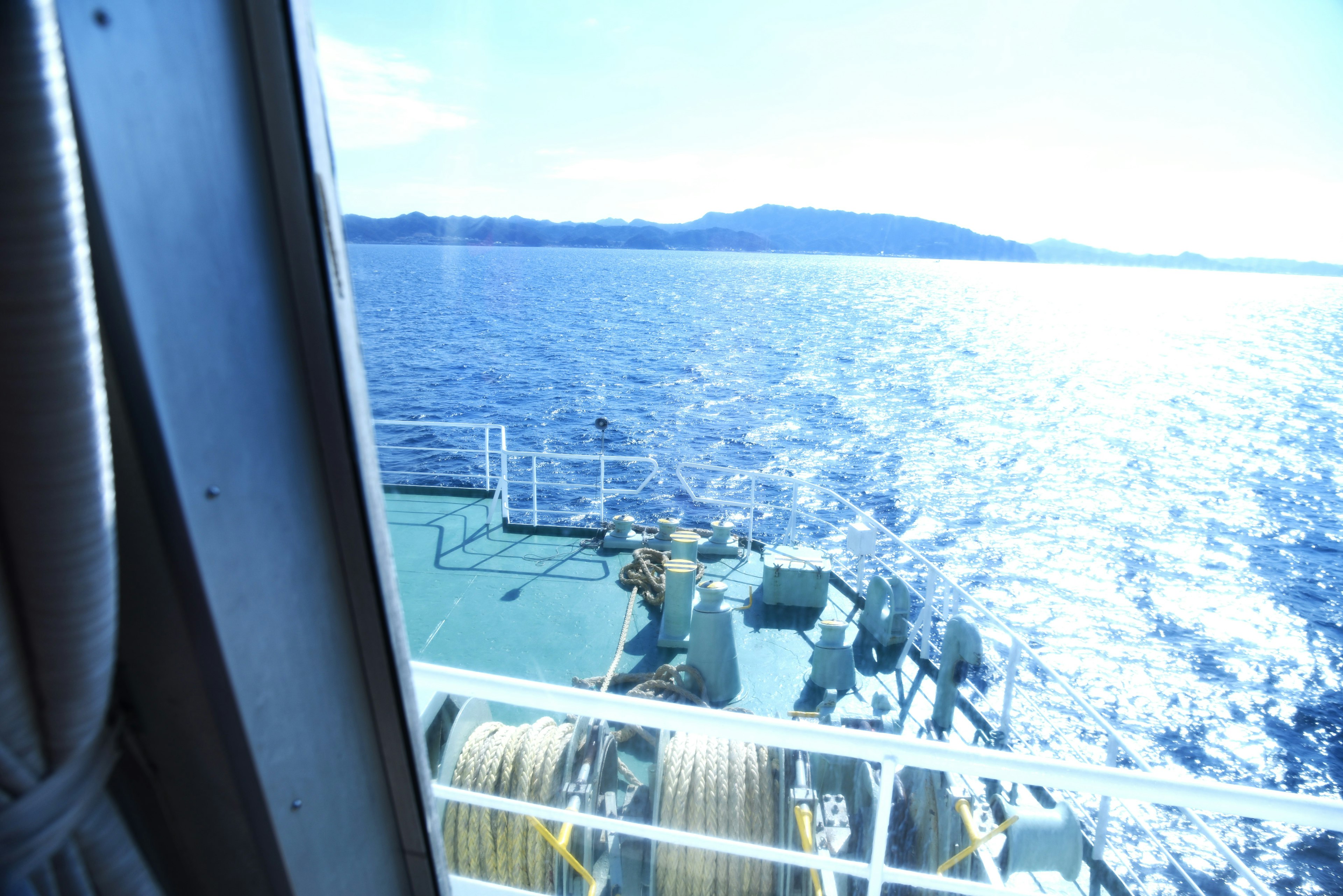 Deck of a ship with ocean view and distant mountains