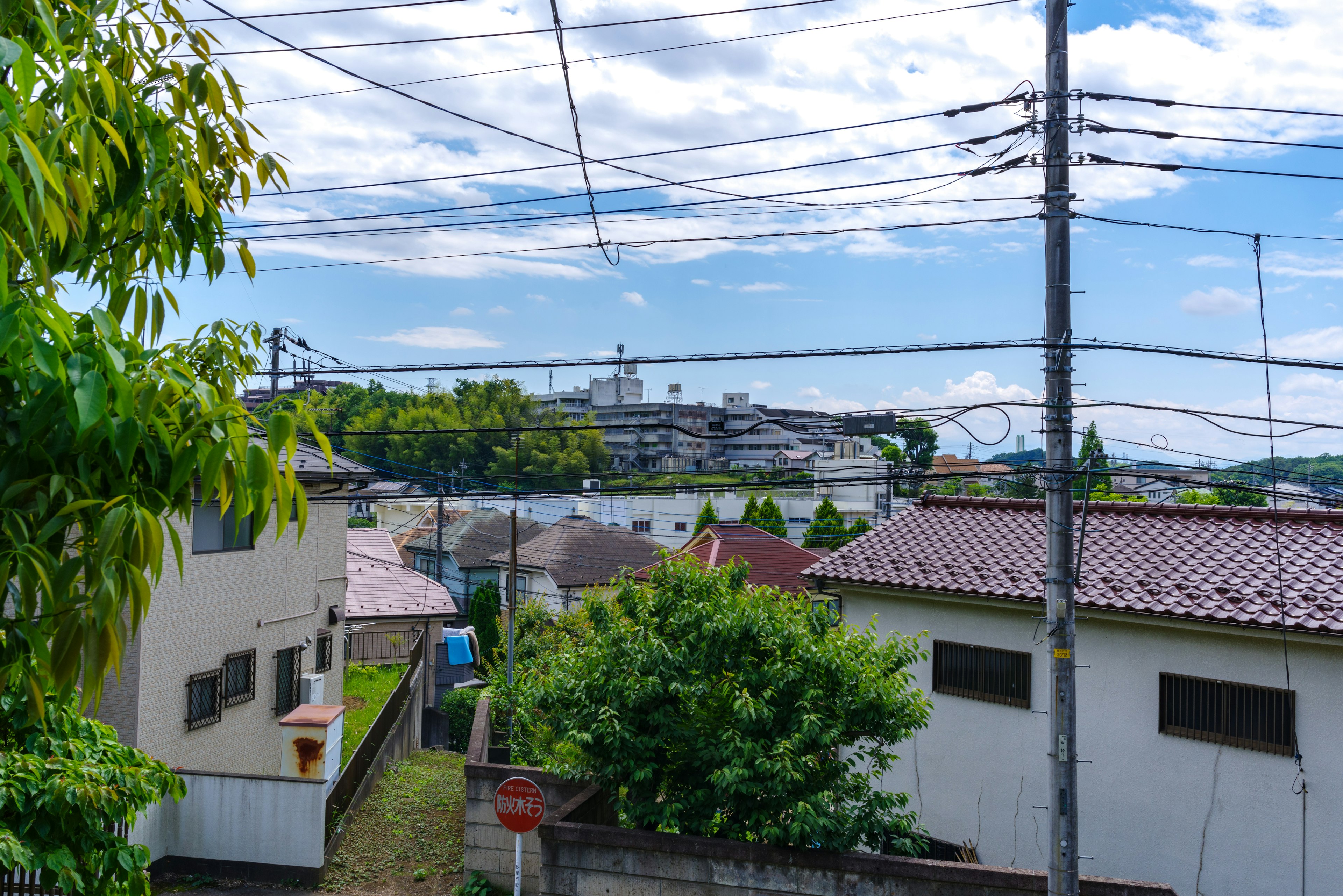 Vue d'un quartier résidentiel avec un ciel clair et des lignes électriques