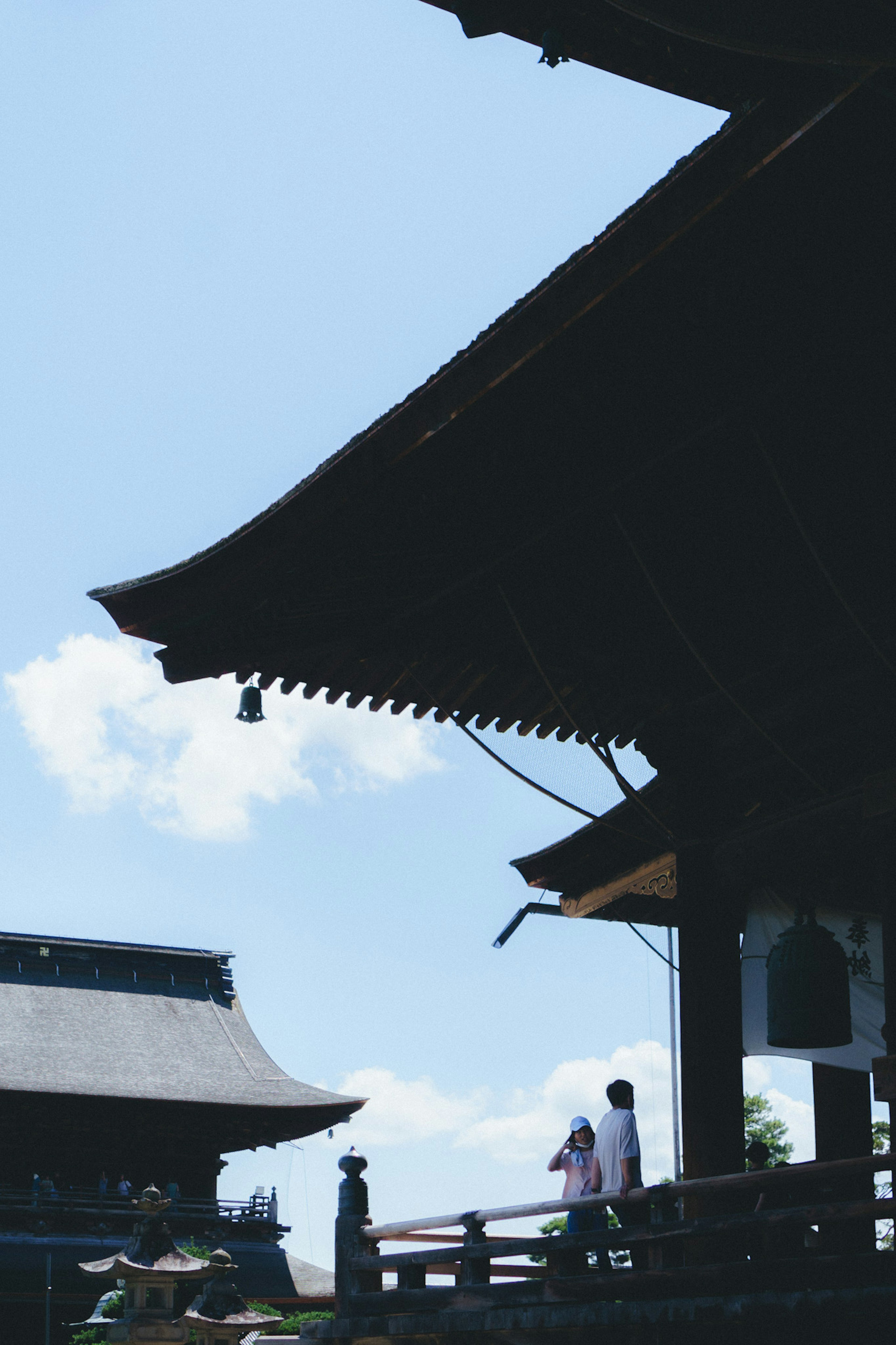 Traditional Japanese architecture under a blue sky with people