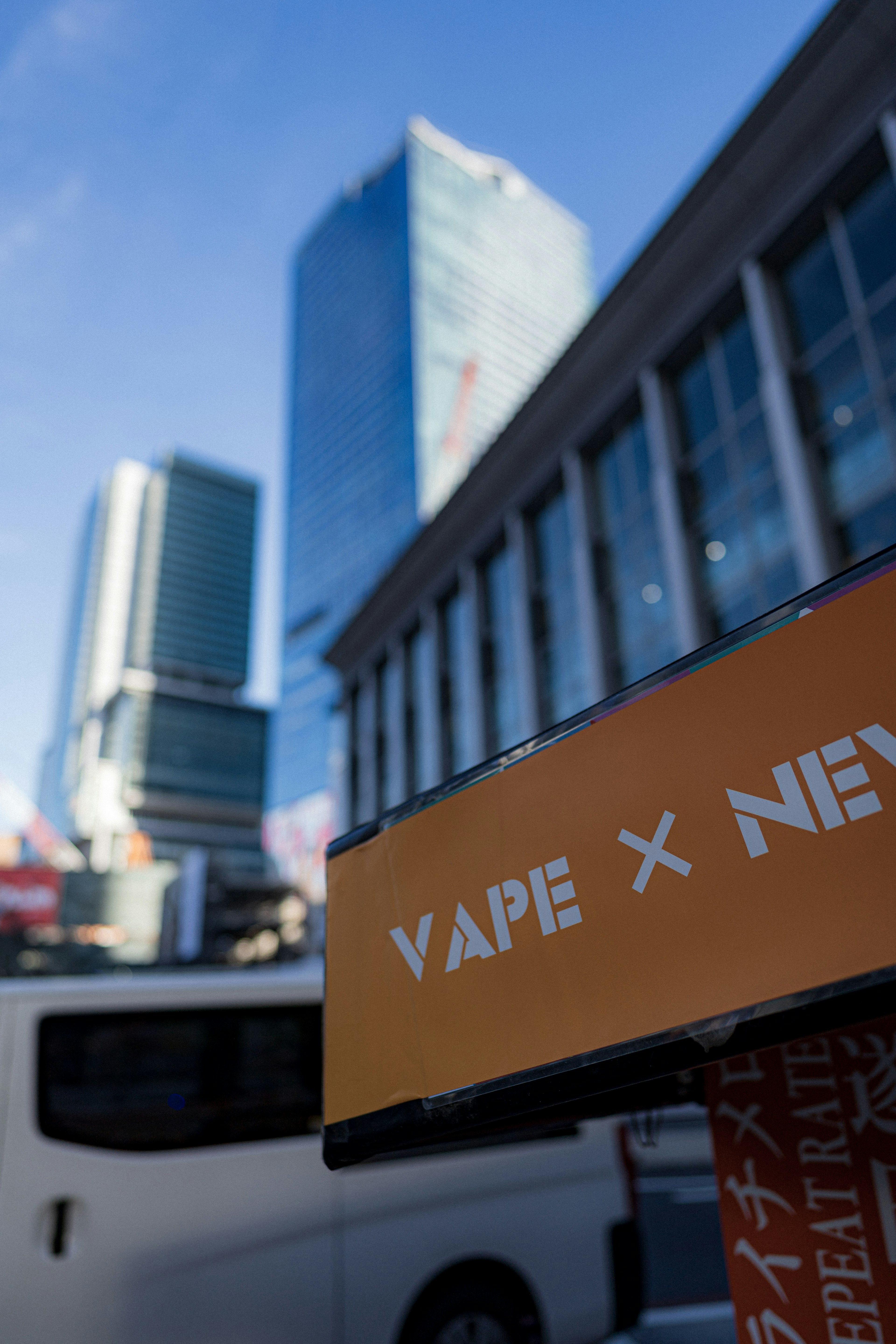 ทิวทัศน์เมืองที่มีป้าย VAPE X และอาคารสมัยใหม่