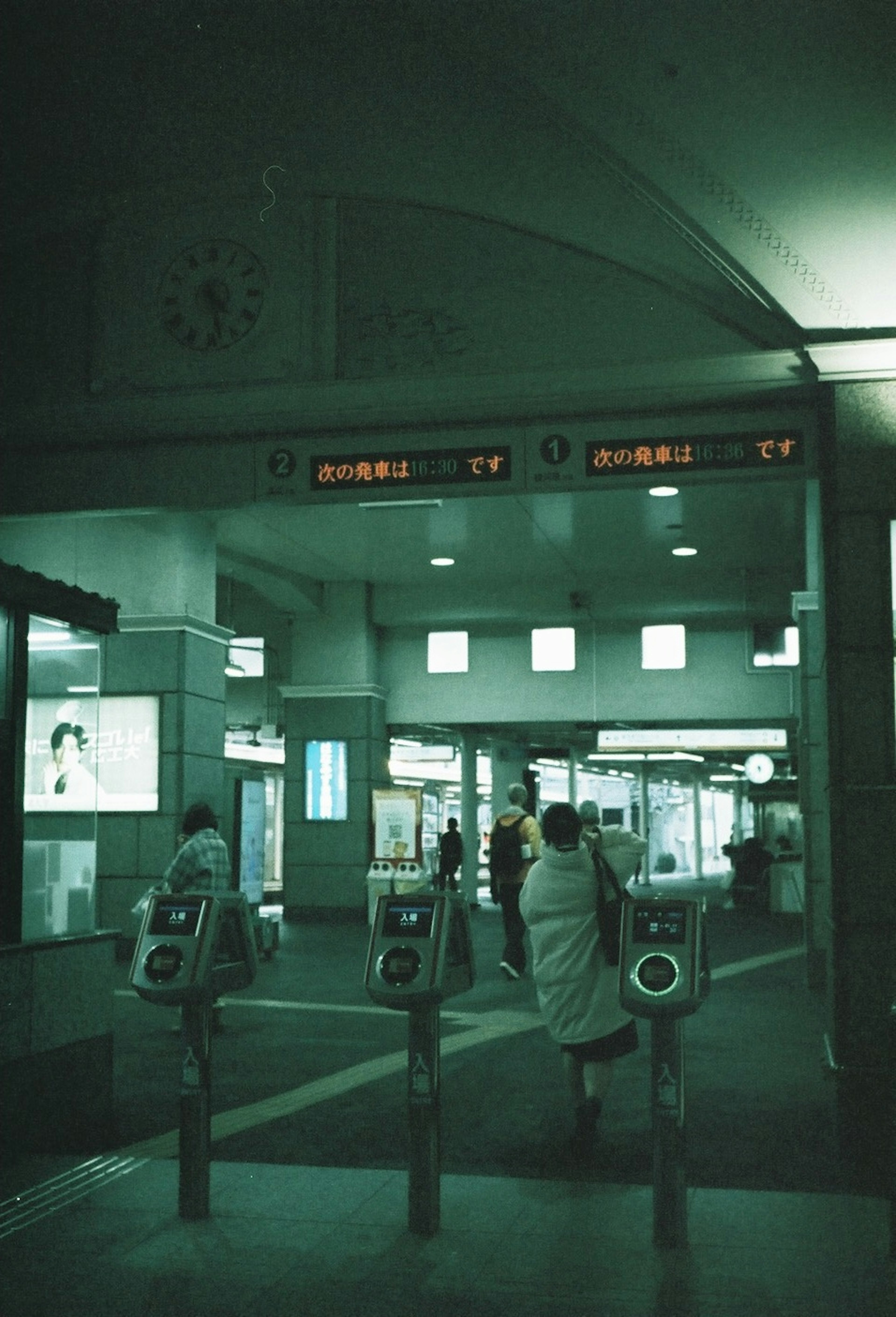 駅の改札口と電光掲示板がある薄暗い内部の風景