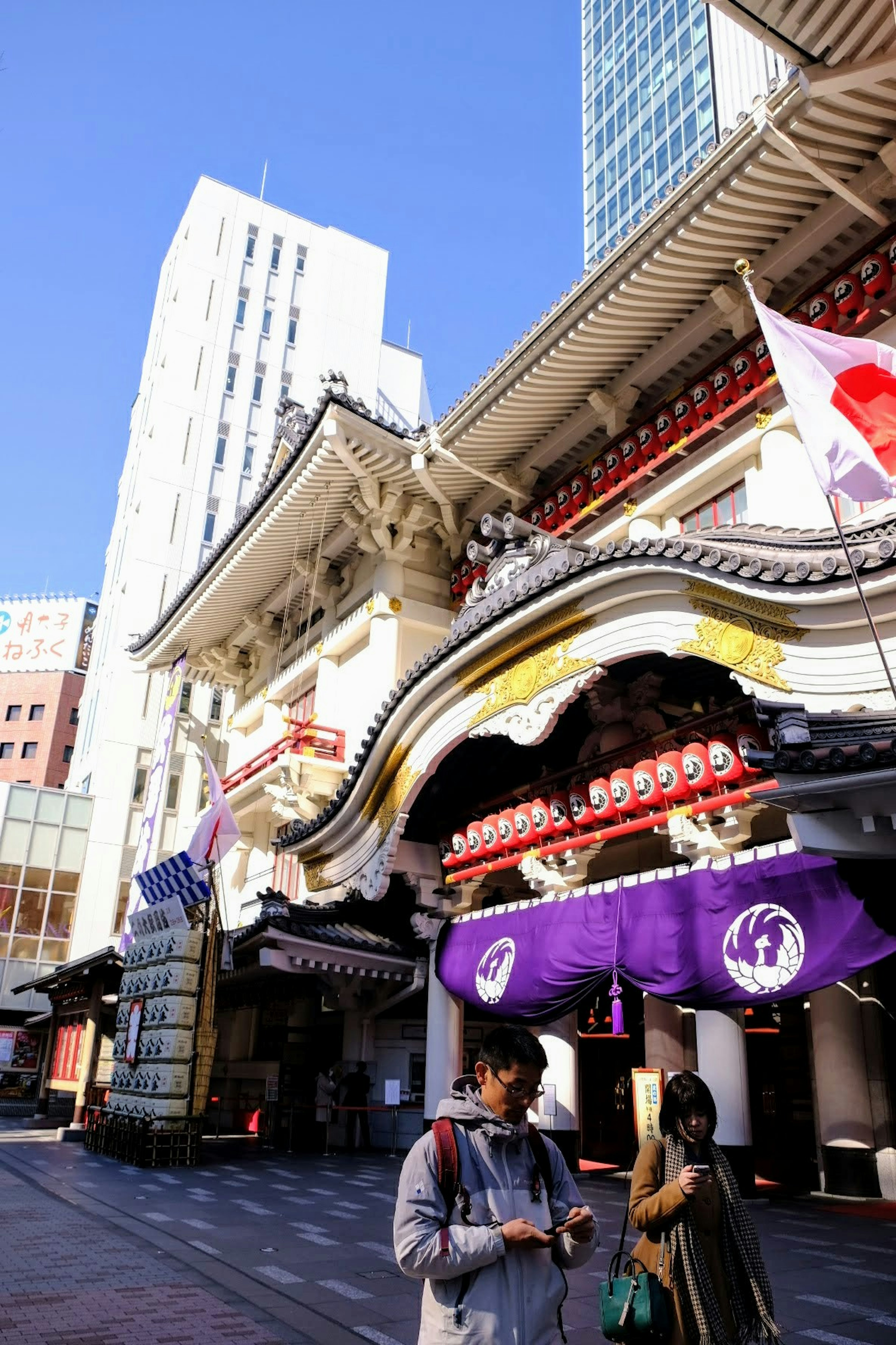 Edificio tradicional japonés con rascacielos modernos de fondo personas caminando por la calle