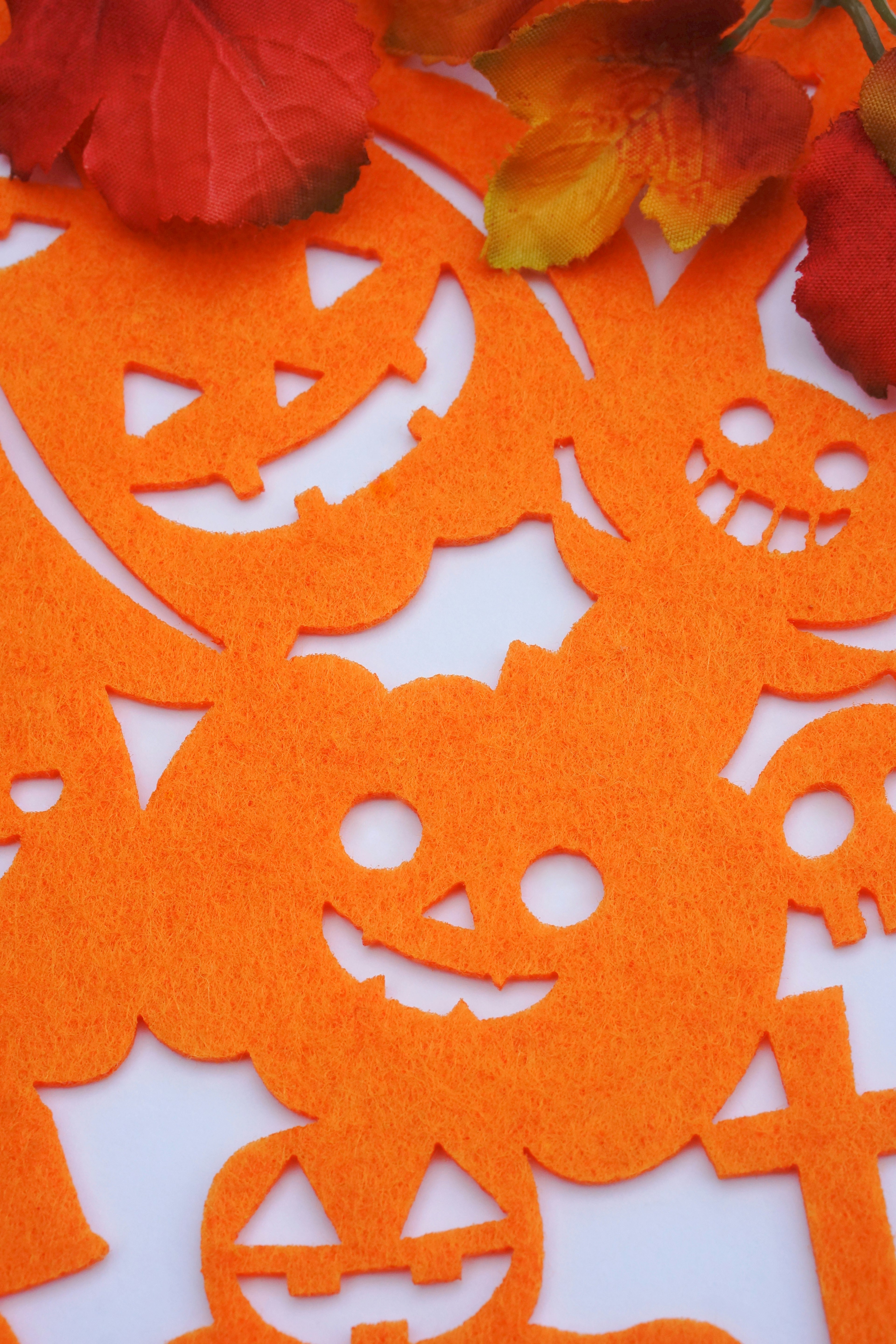 Découpes orange sur le thème d'Halloween avec des citrouilles souriantes sur un fond blanc