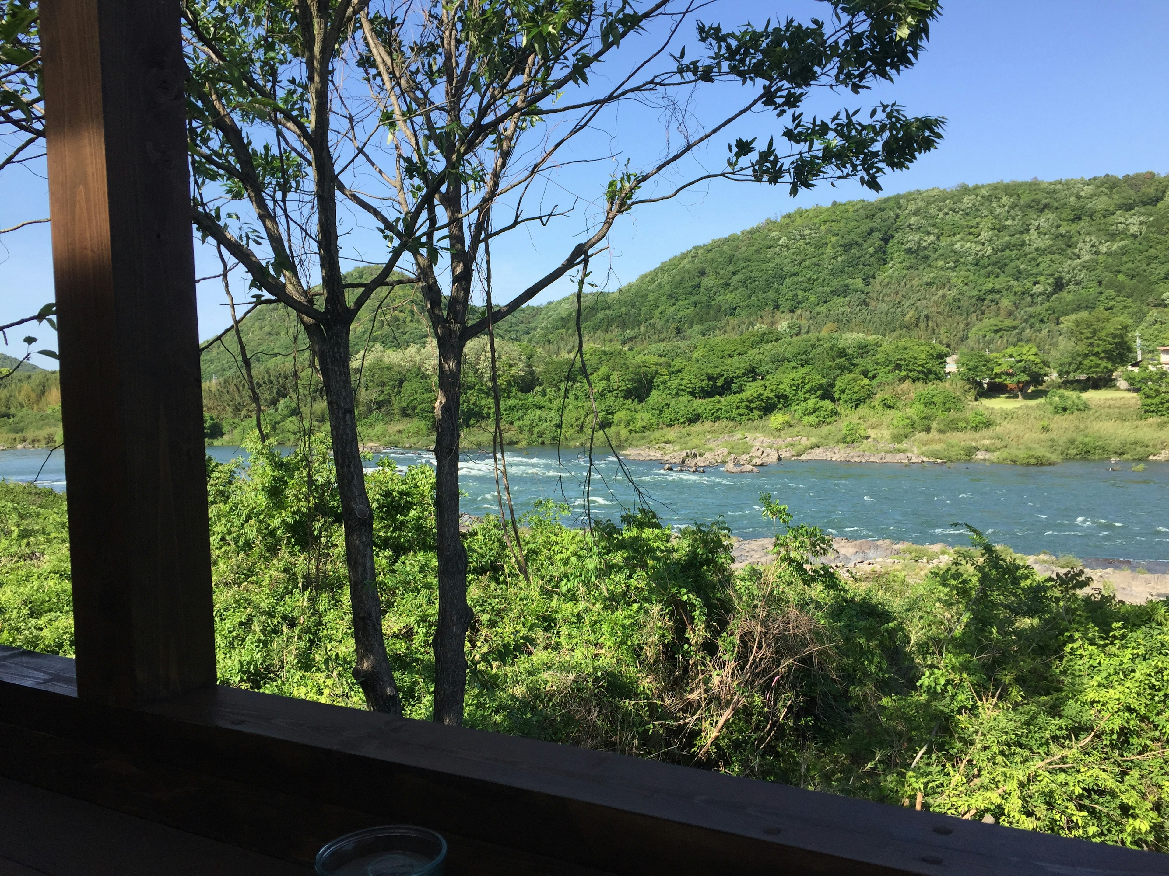 緑豊かな山と川の景色が見える窓辺の風景