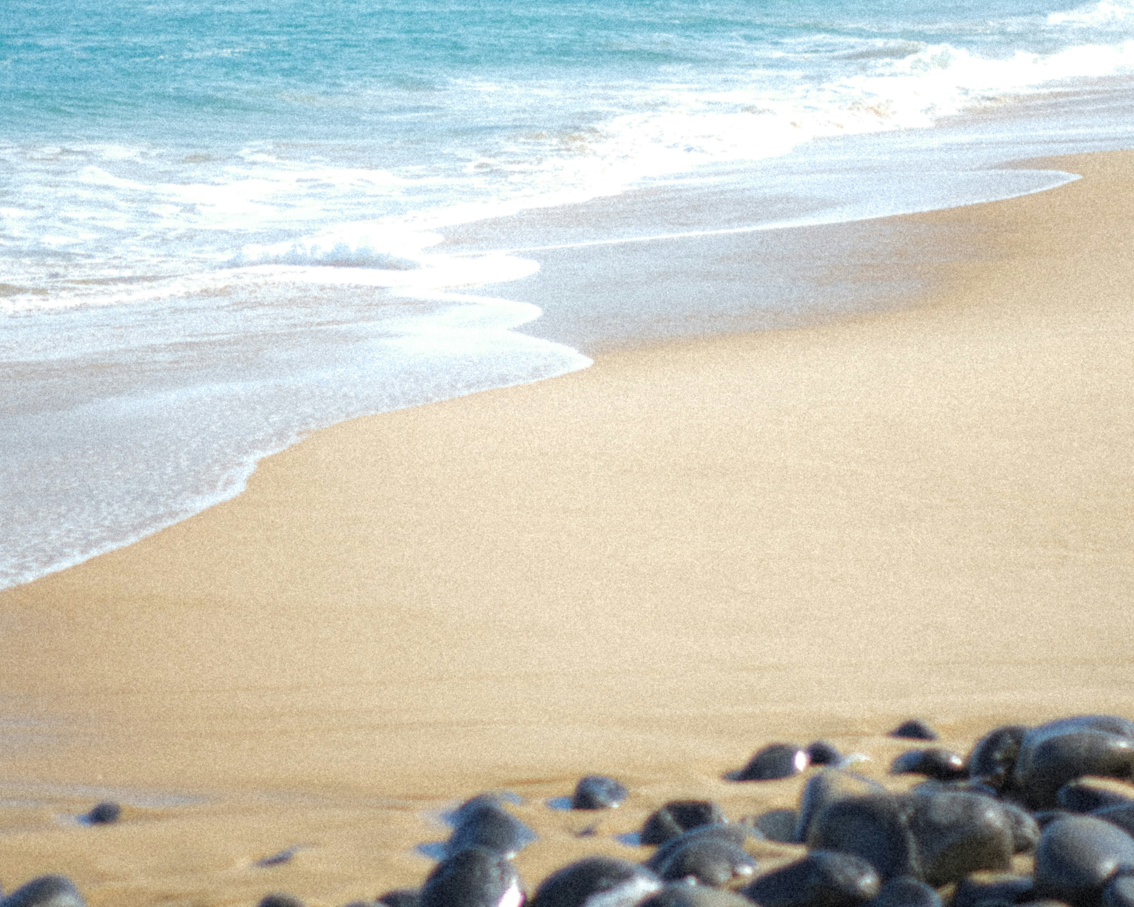 Pemandangan pantai dengan ombak dan kerikil