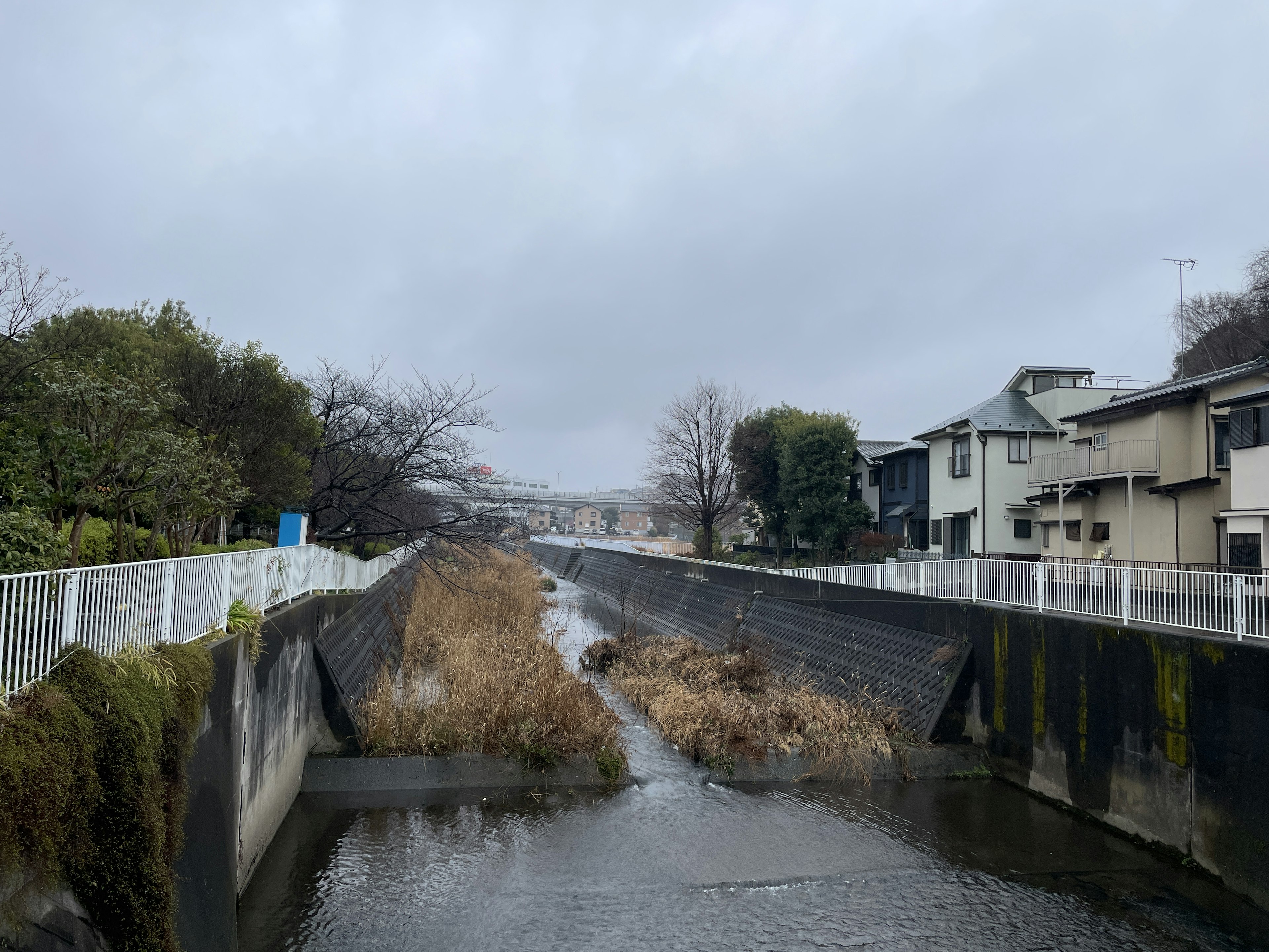 A river bordered by buildings under a cloudy sky