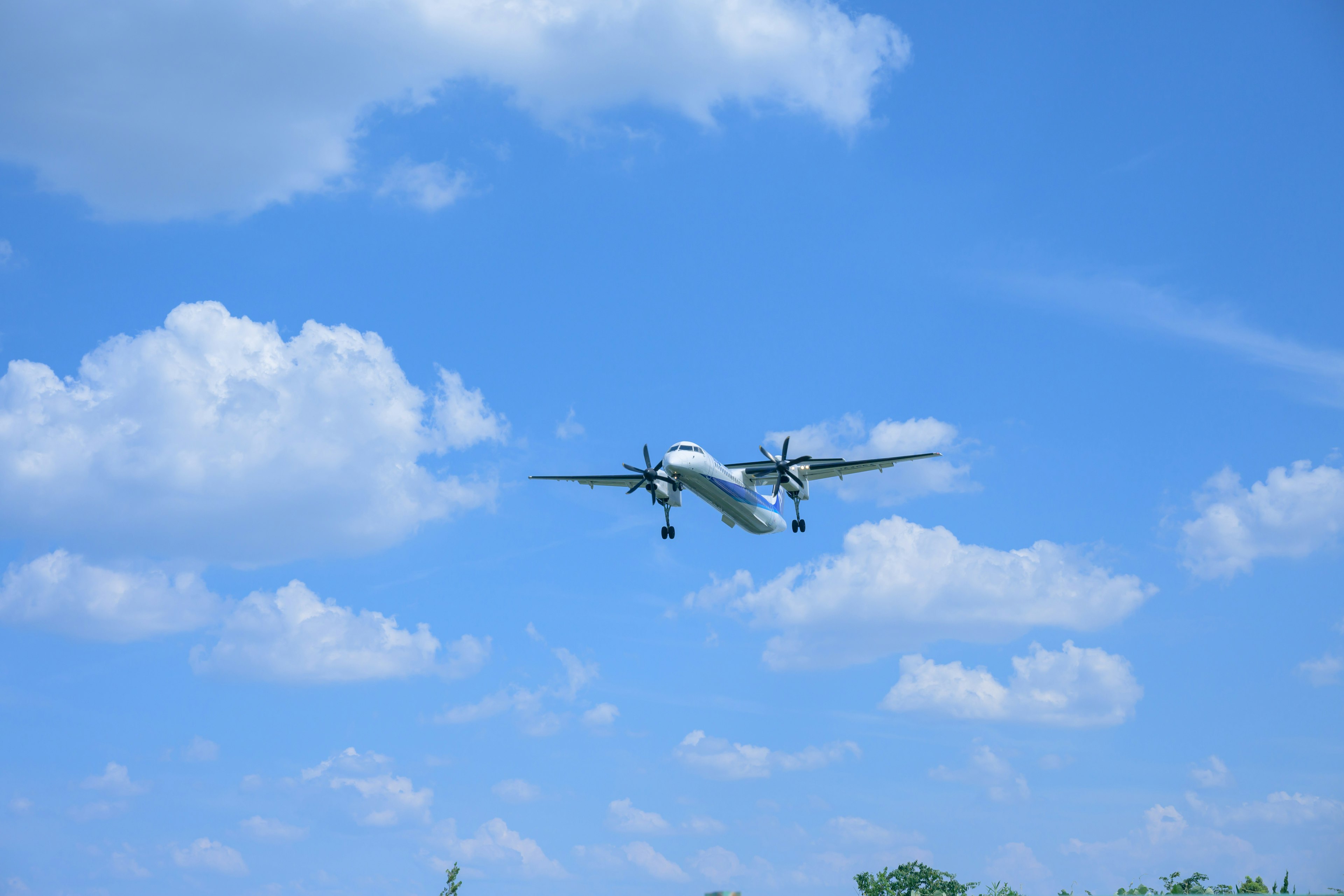 Avión volando en un cielo azul con nubes blancas