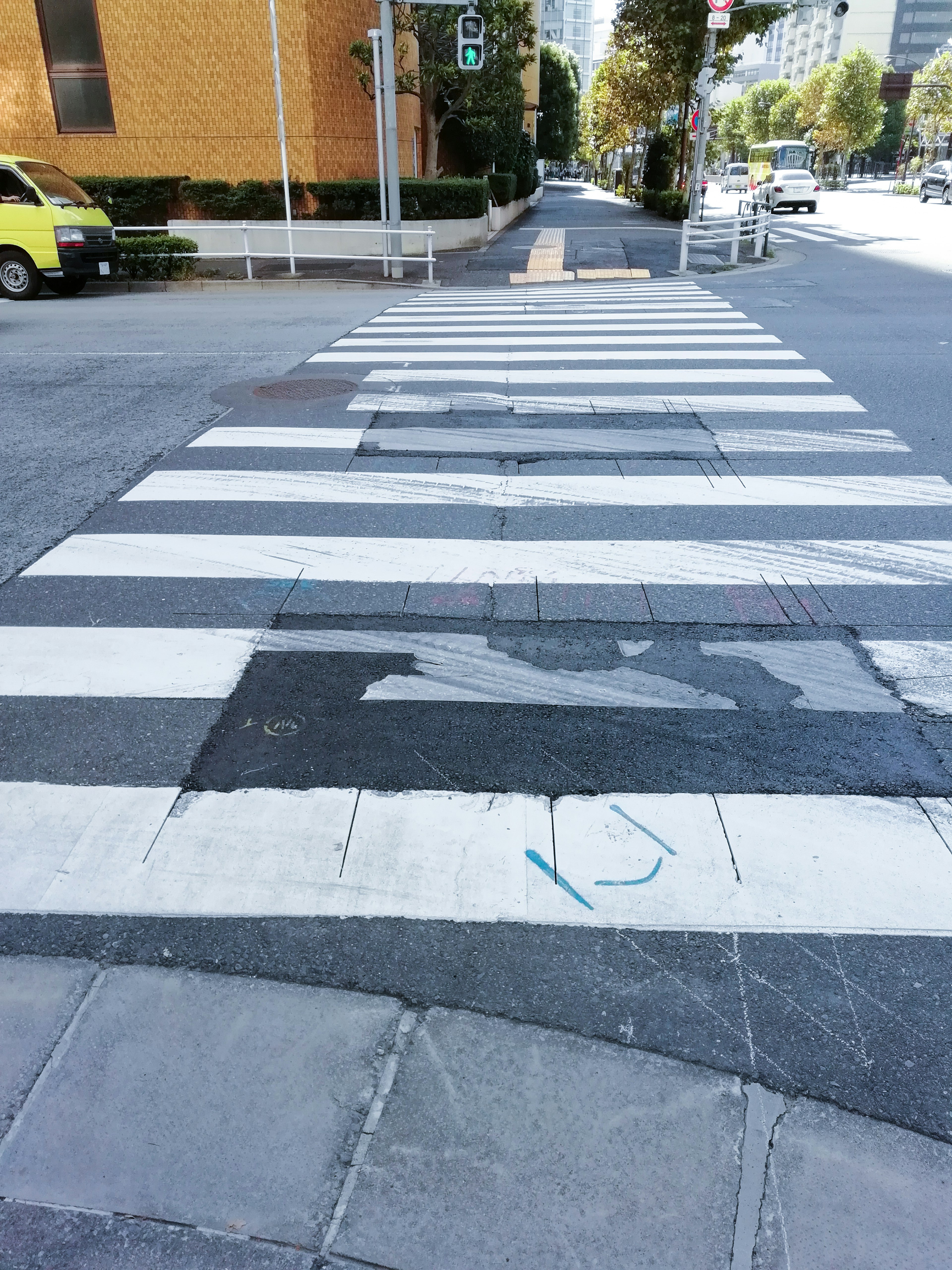 Zebrastreifen mit verblassten Streifen und städtischer Umgebung