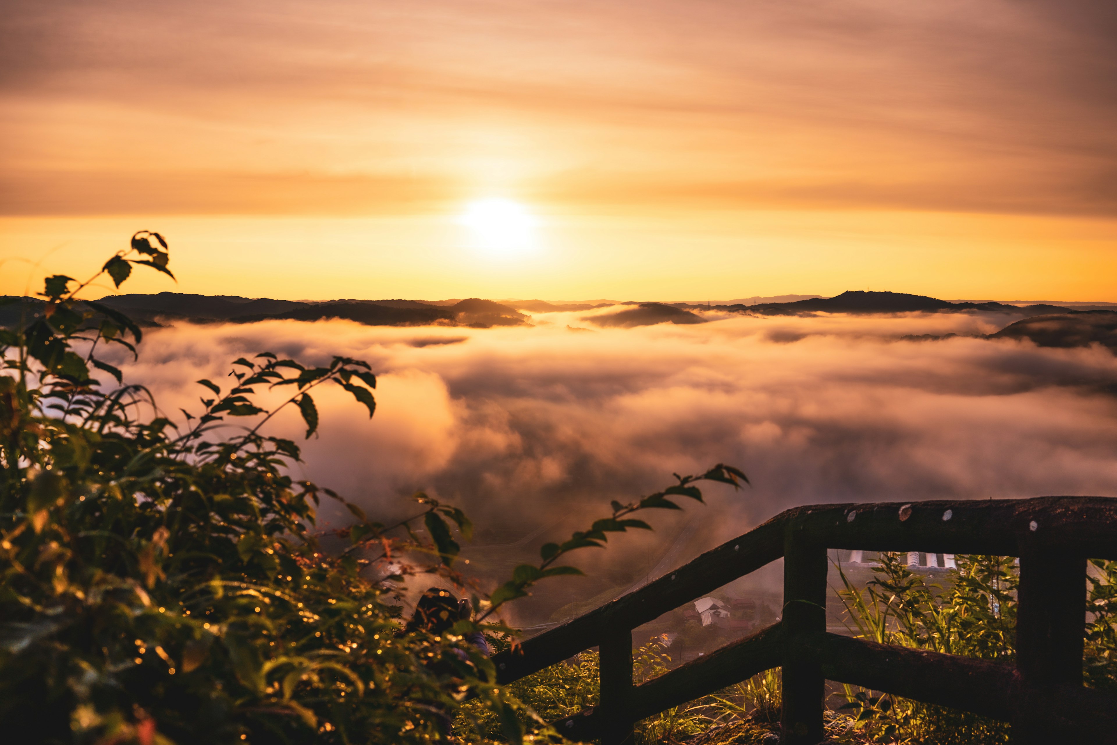 Vista escénica de un atardecer sobre un mar de nubes