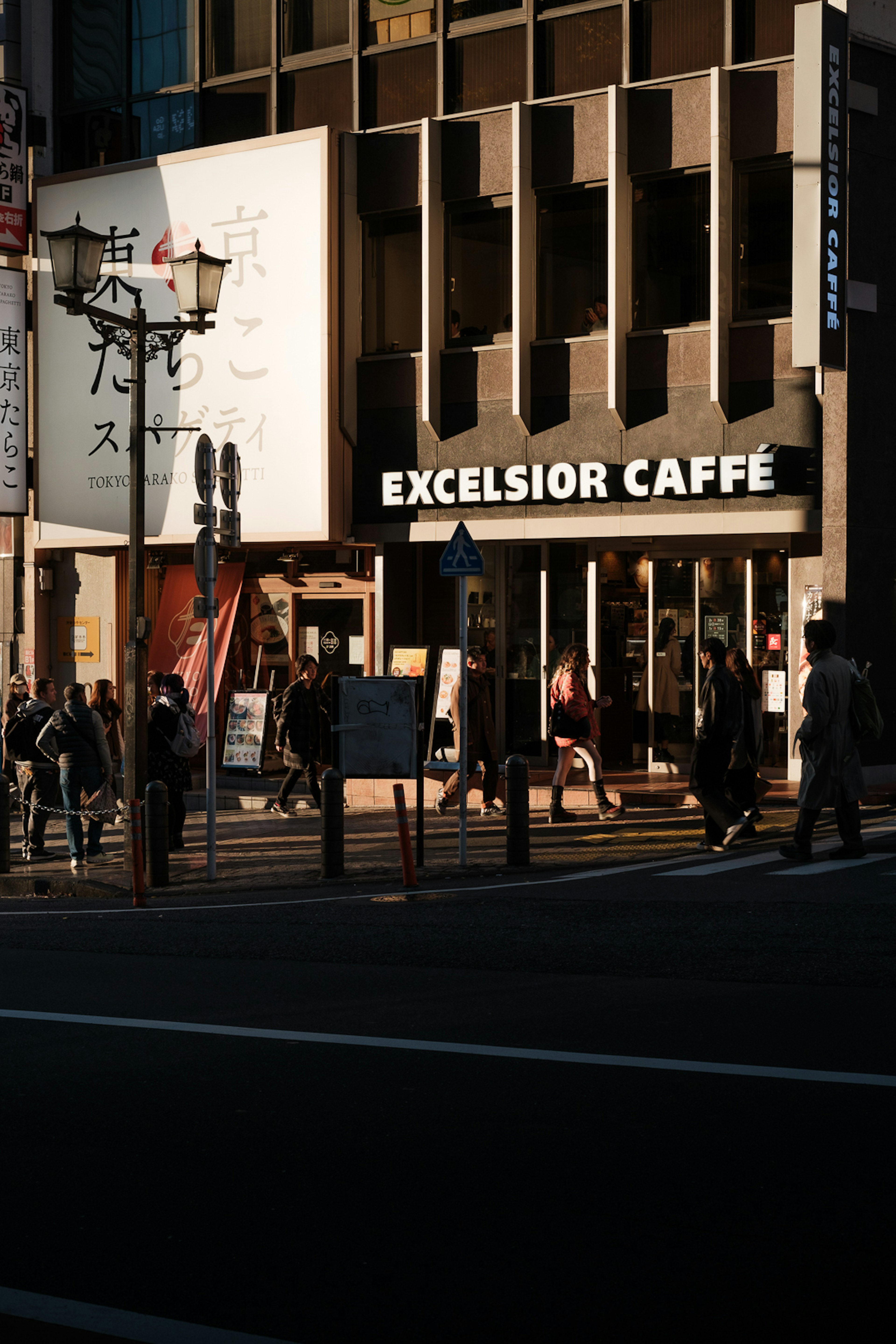 Coin de rue animé avec le panneau Excelsior Caffè