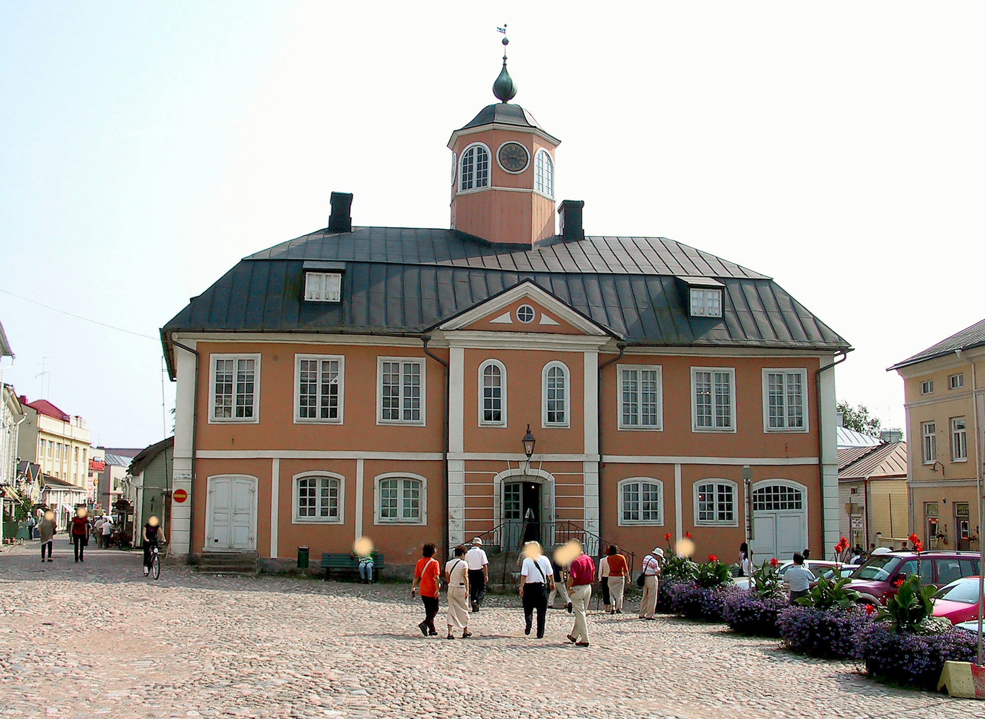 Historic building with orange exterior located in a square