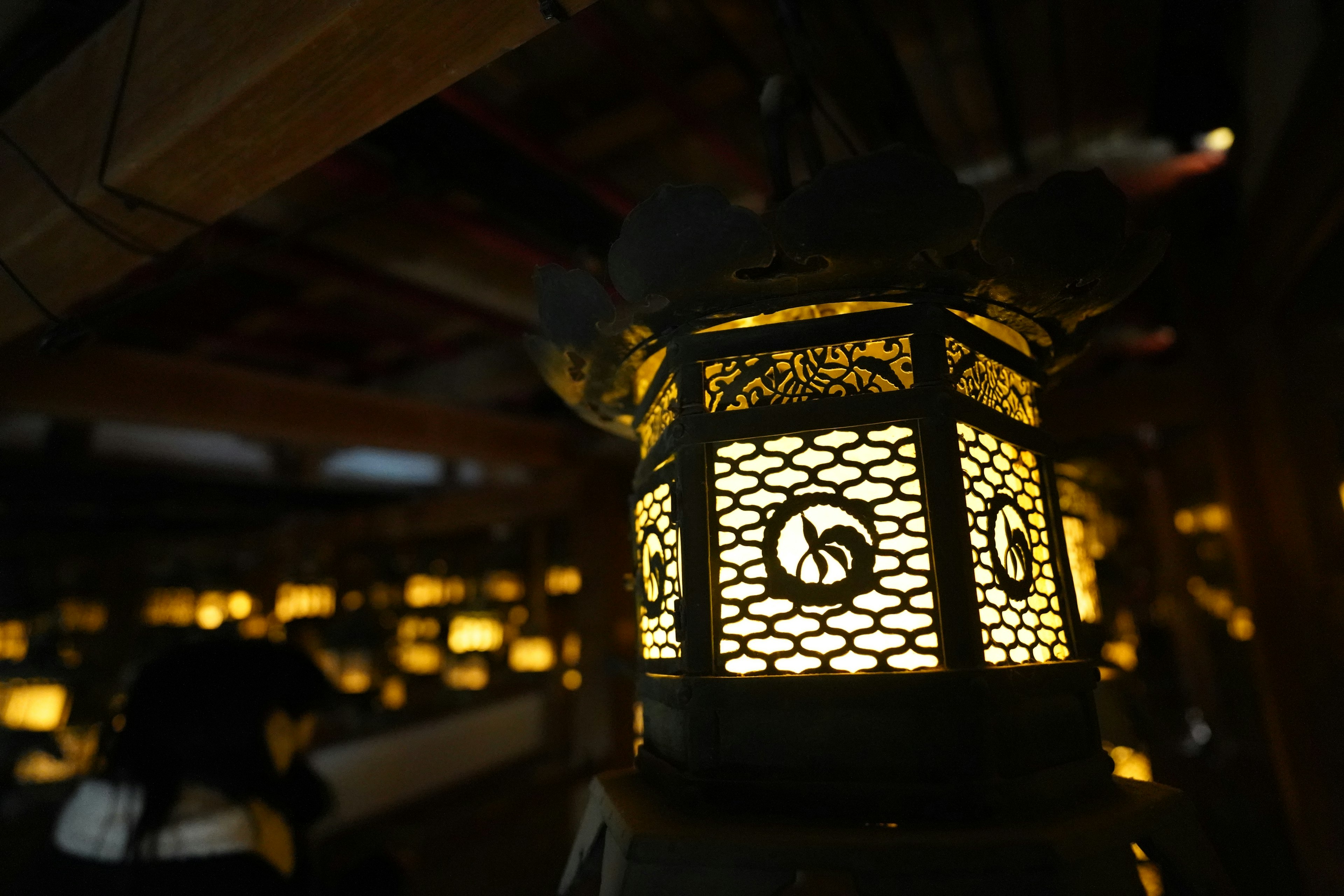 A beautiful lantern glowing against a dark background A delicately designed lantern emitting warm light