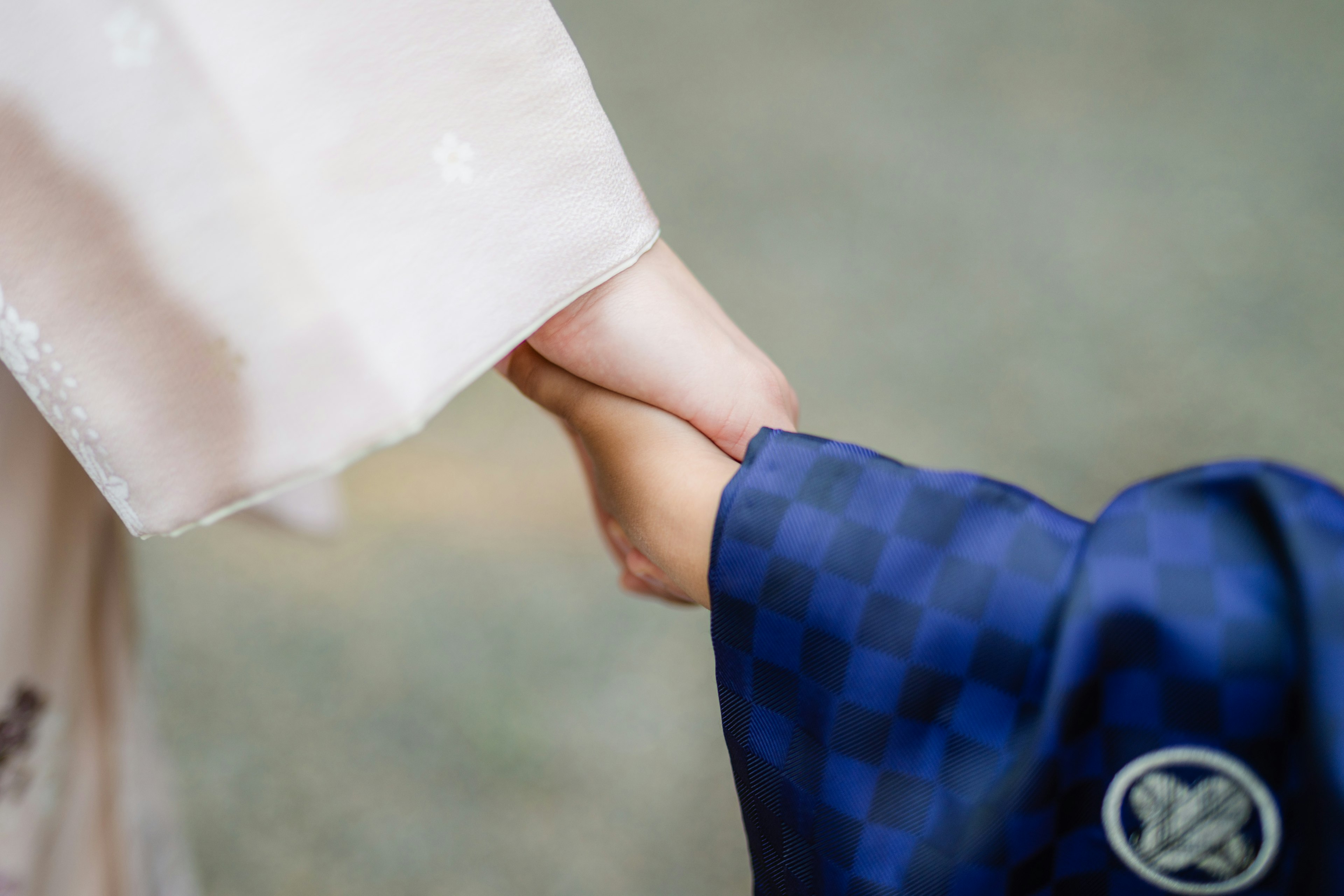 An adult hand holding a child's hand in a gentle connection