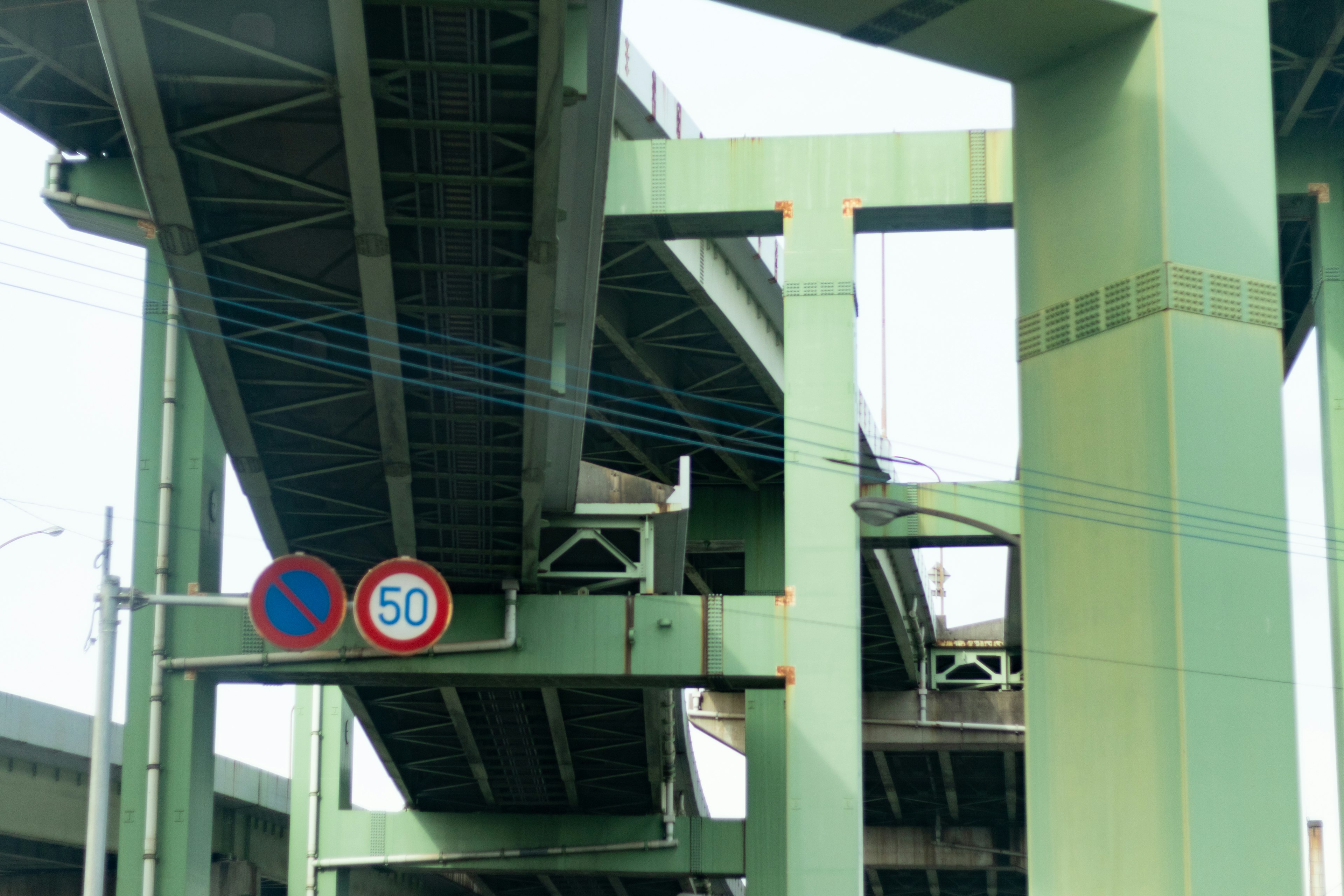 Urban scene featuring green overpass and traffic signs