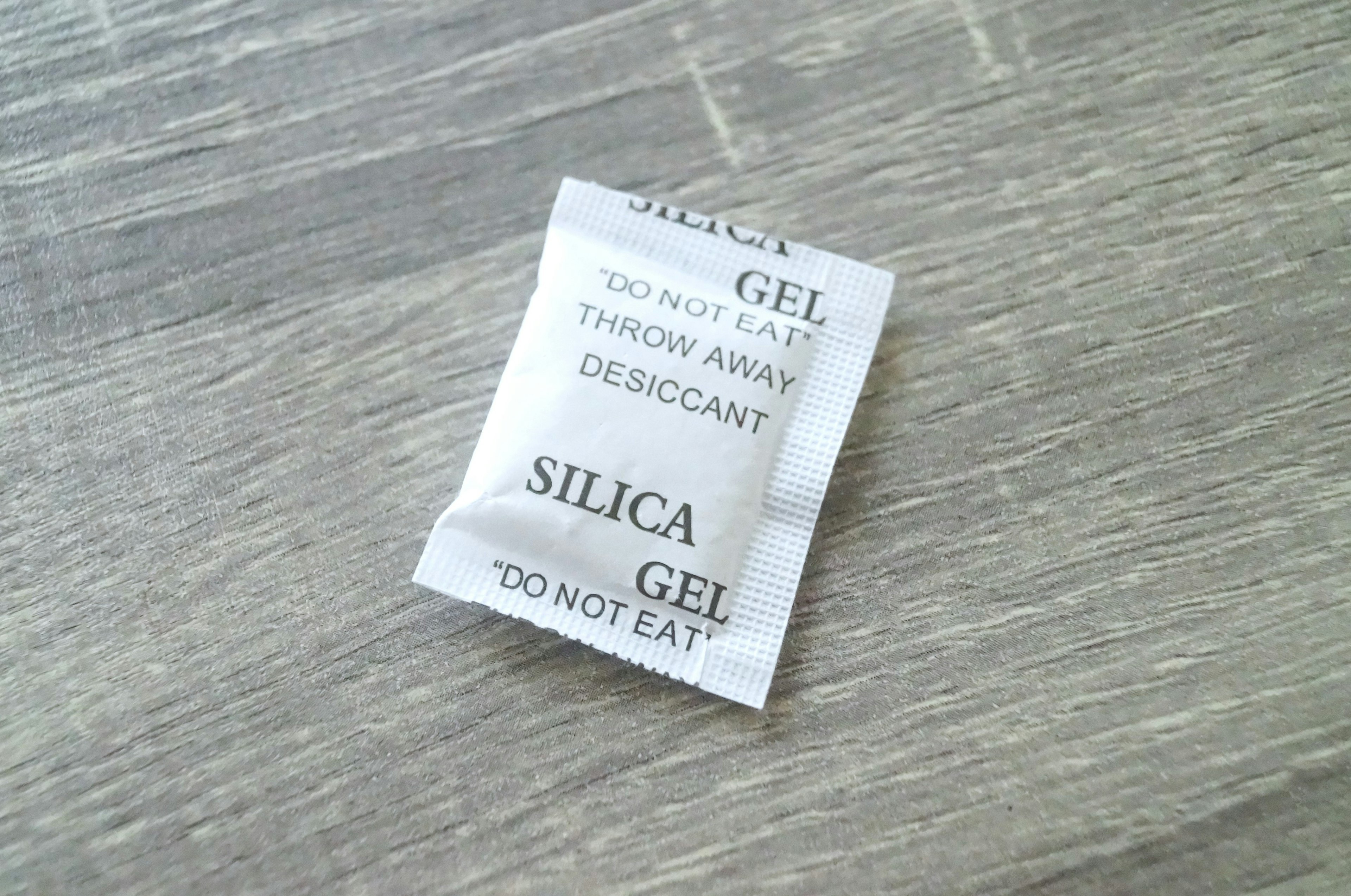 Silica gel packet placed on a wooden surface