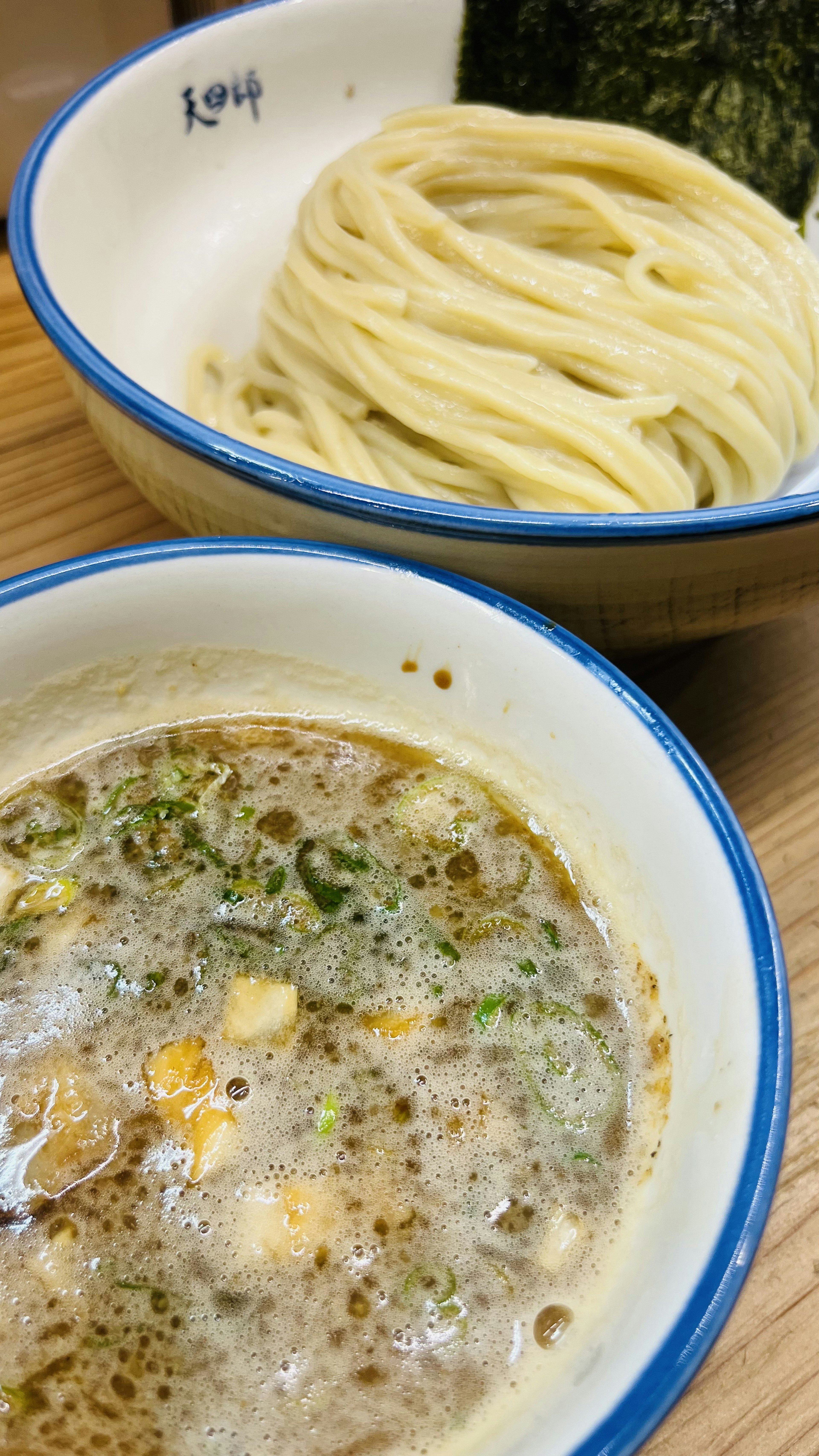 Una ciotola di brodo cremoso servita con noodles e alga