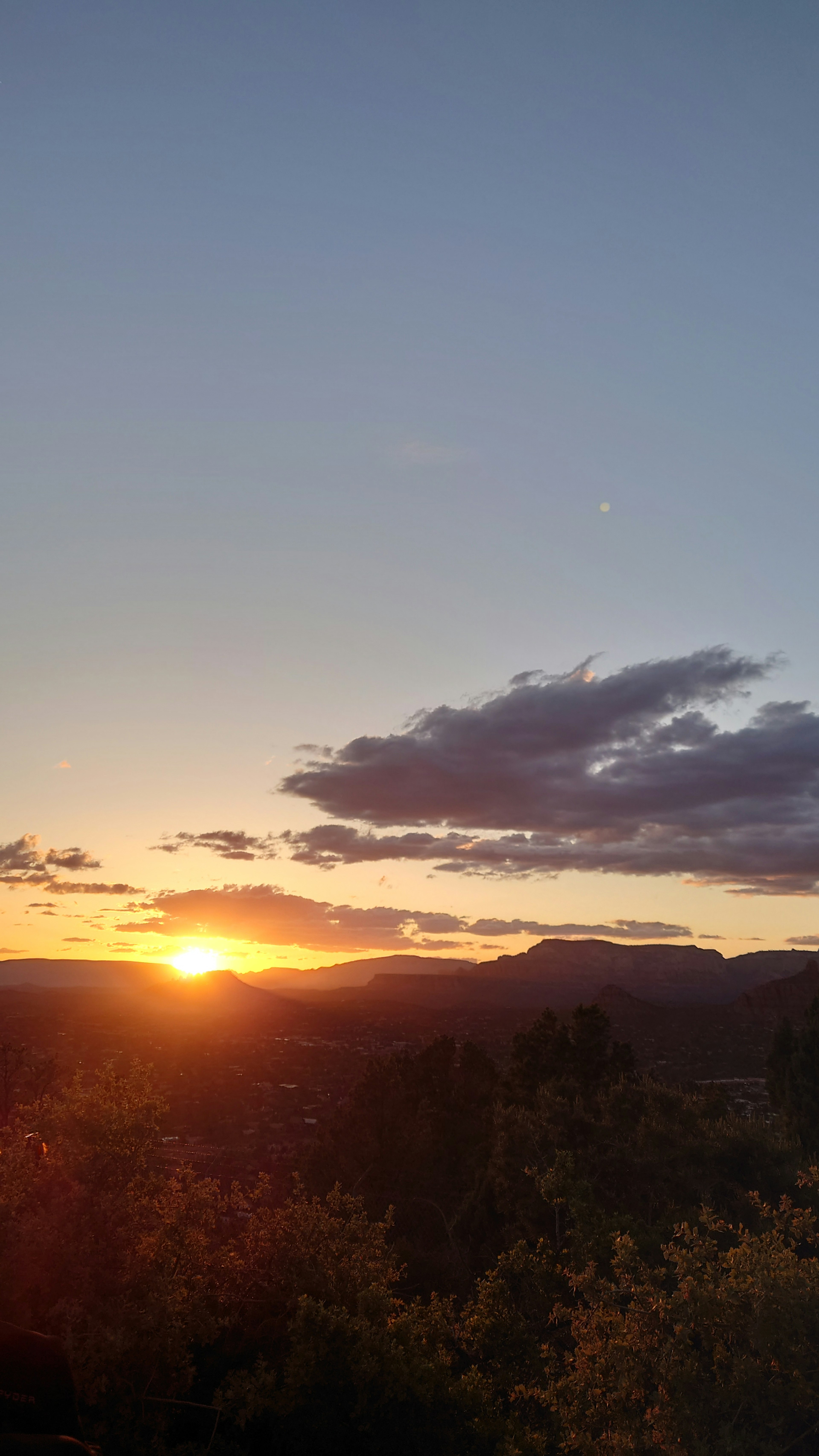 Beautiful landscape of sunset behind mountains with blue sky and clouds