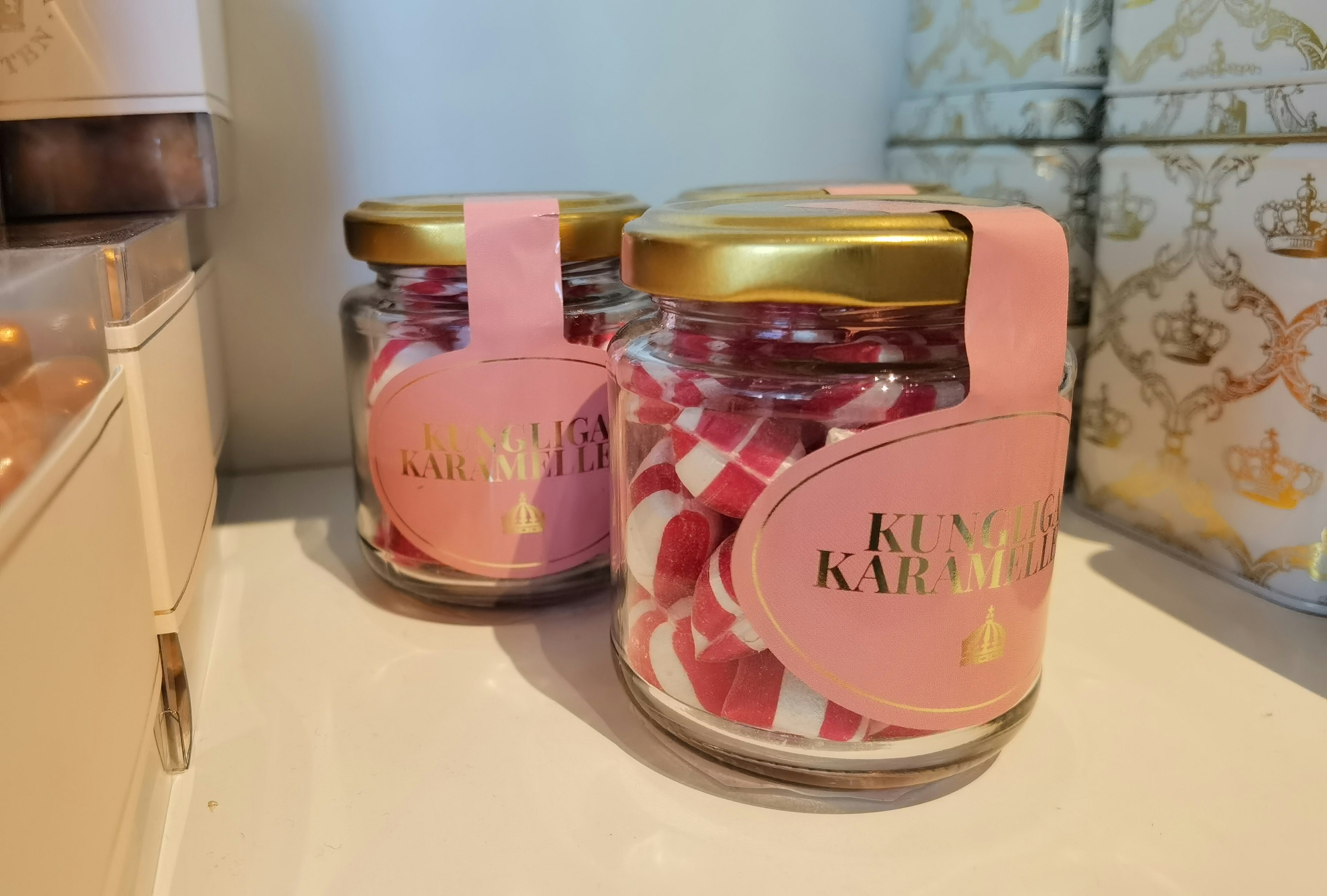 Two glass jars filled with red and white candies placed on a shelf