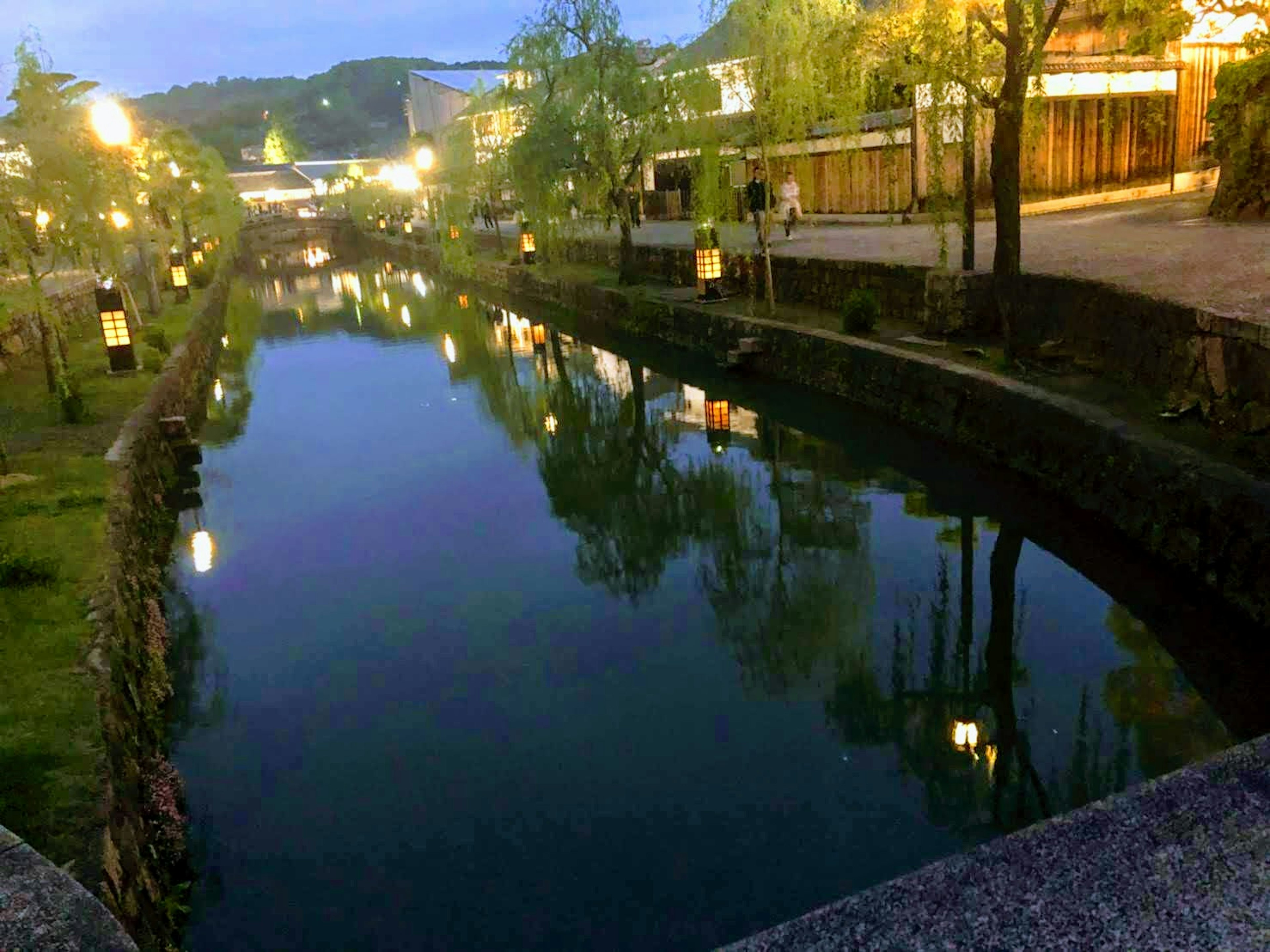 Ruhige Nachtansicht eines Flusses mit Lichtern, die sich im Wasser spiegeln